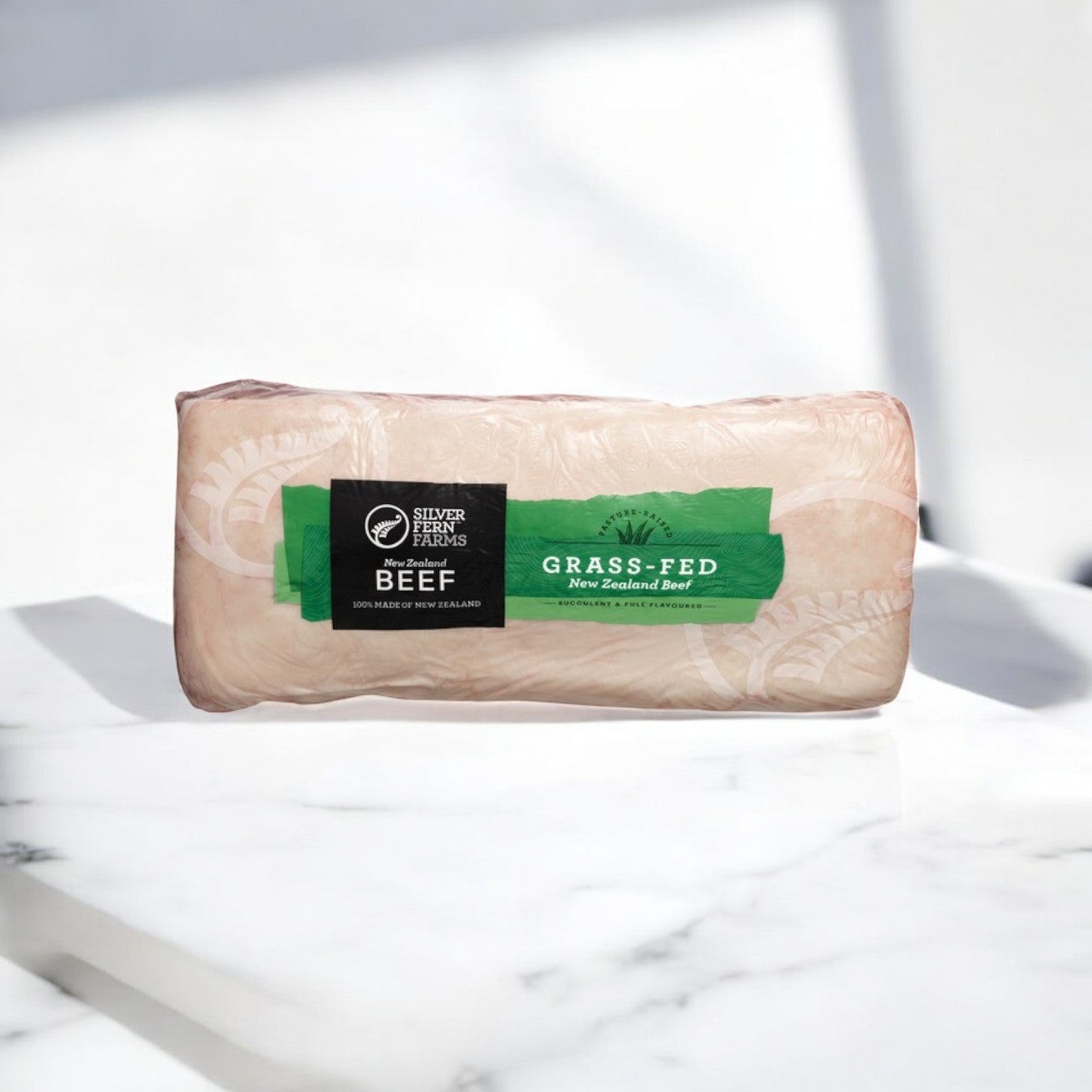 A package of "Halal New York Top Loin Beef - 11 lbs Average" from Silver Fern Farms rests on a white surface, its green and black design boasting the unbeatable tenderness and flavor from nutrient-rich pastures in New Zealand.
