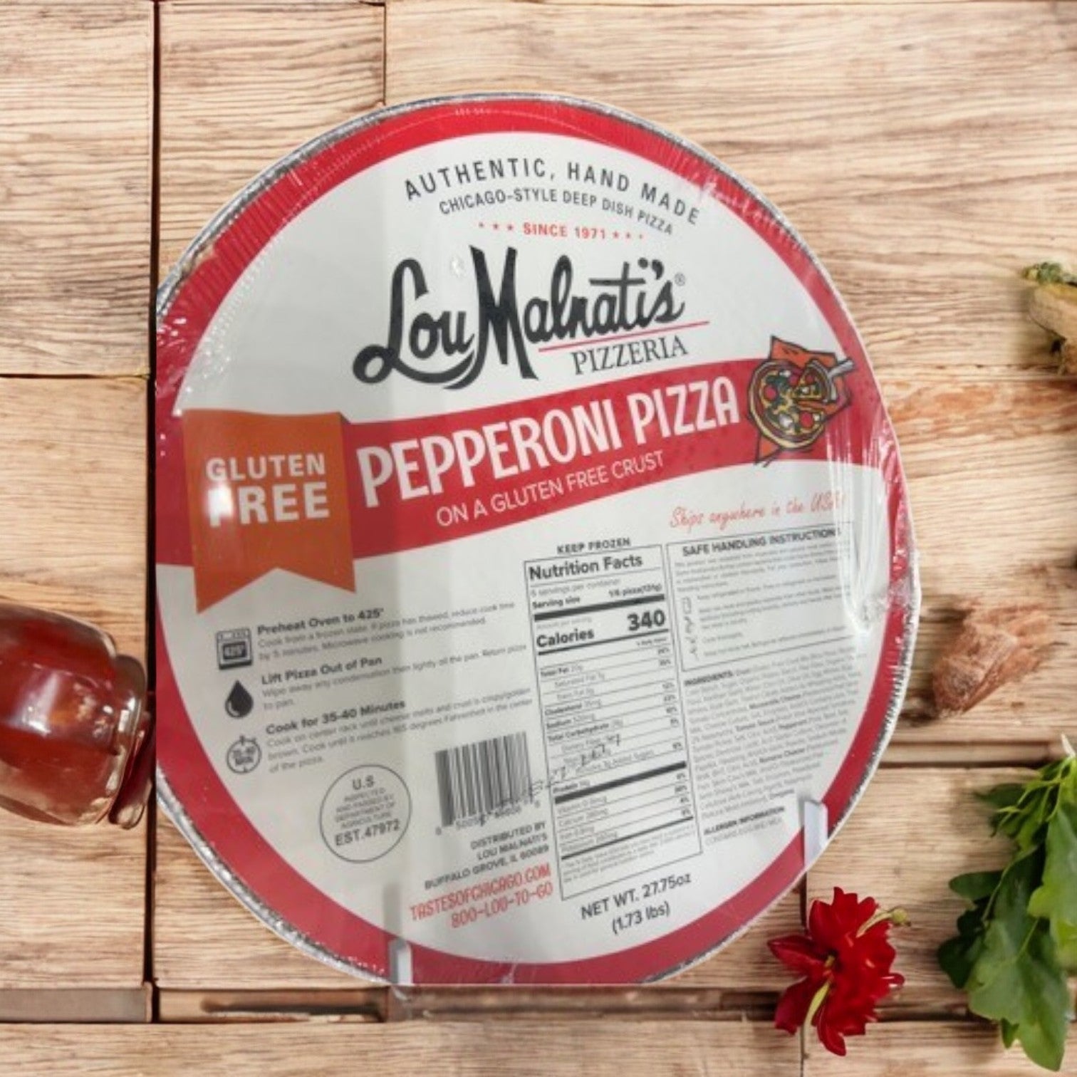 Lou Malnati's Gluten-Free Crust Combo Pack, featuring a set of three pizzas, rests on a wooden surface accented by a small red flower.