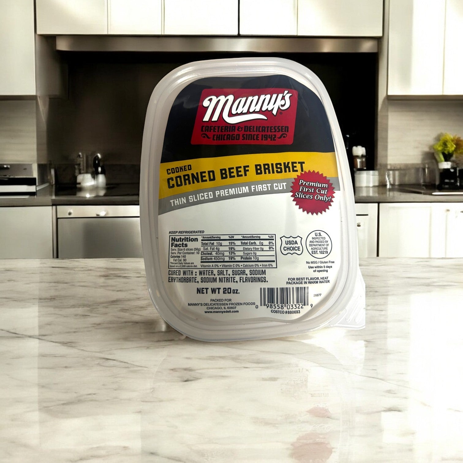 A container of Manny's Deli 4 Count Combo! cooked corned beef brisket sits on the marble countertop, displaying its "premium first cut" label and nutritional details. Surrounded by kitchen appliances, this dish brings the classic Chicago deli taste to your home.