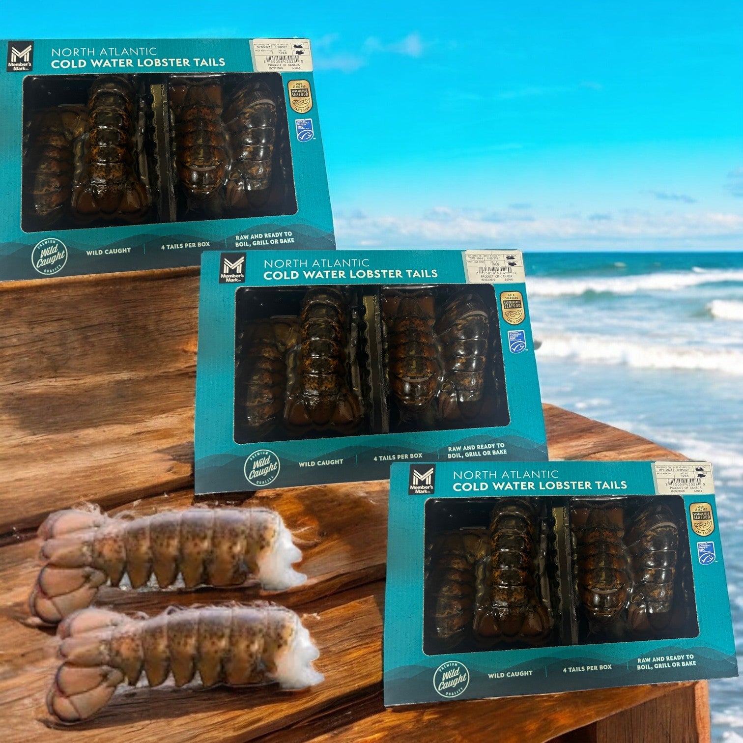 Three packs of Member's Mark Cold Water Lobster Tails, frozen and four-count each, lie on a wooden surface with three loose frozen lobsters and the ocean in the background.