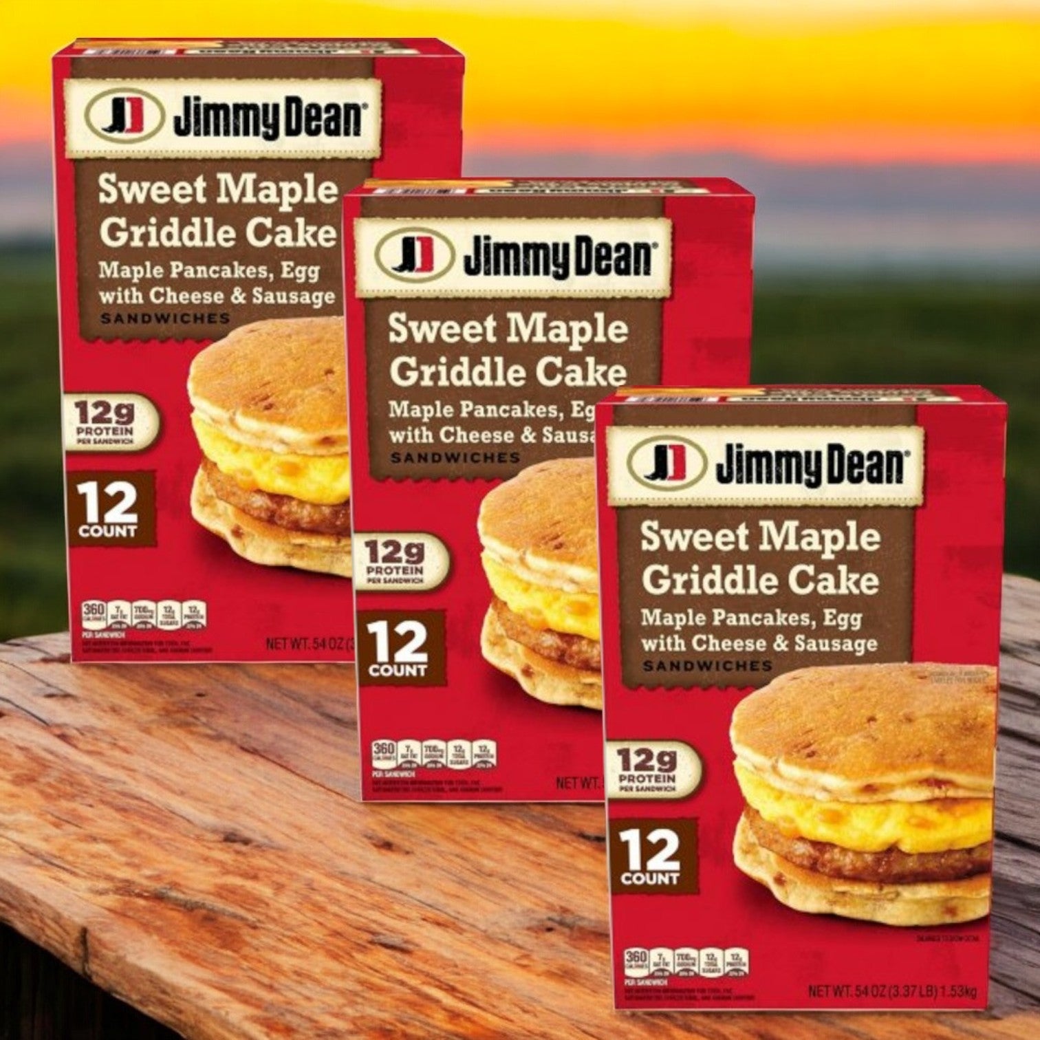 Three packs of Jimmy Dean Sweet Maple Griddle Cake Breakfast Sandwiches, with savory sausage, egg, and cheese between maple pancakes, are displayed on a wooden surface against a blurred outdoor backdrop.