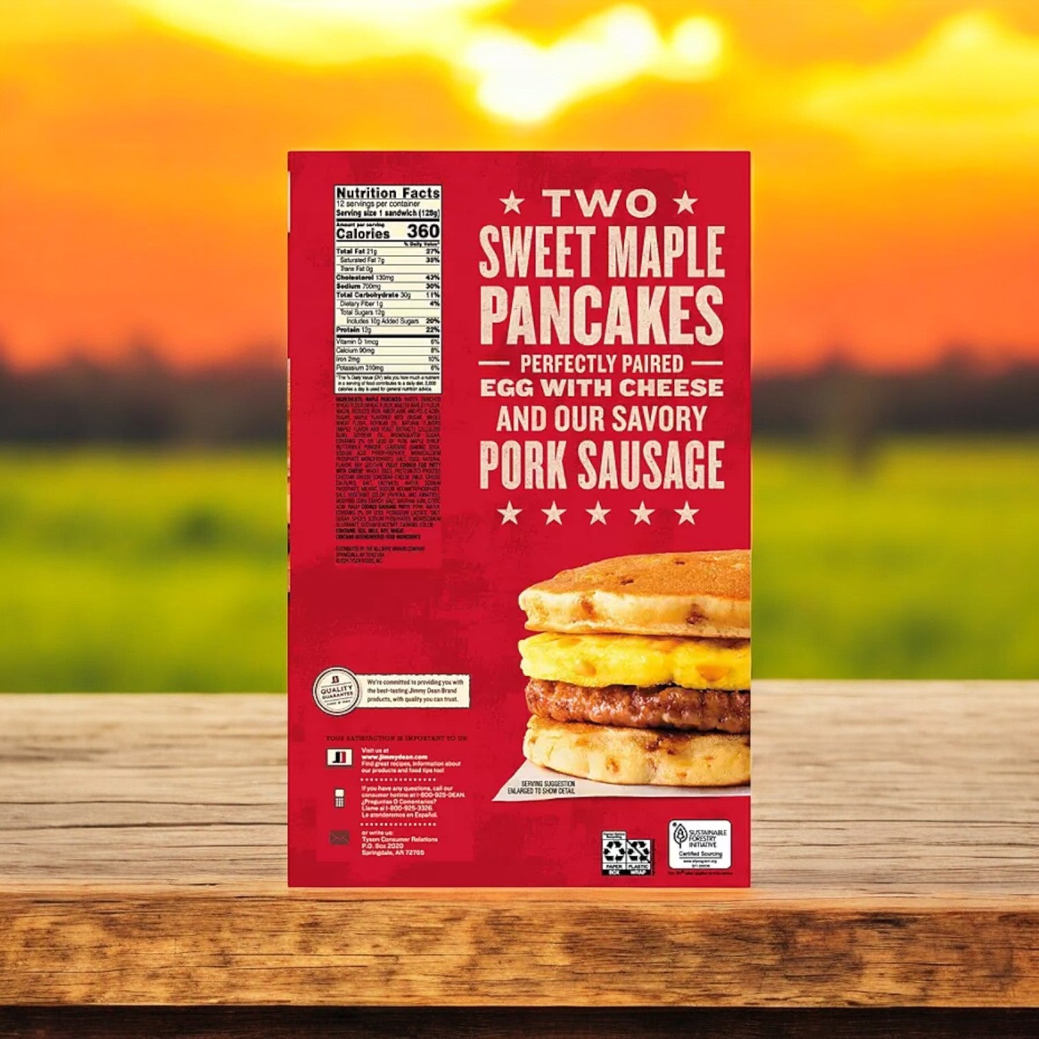 A box of Jimmy Dean Sweet Maple Griddle Cake Breakfast Sandwiches, featuring egg, cheese, and sausage, rests on a wooden surface with a blurred sunset backdrop.