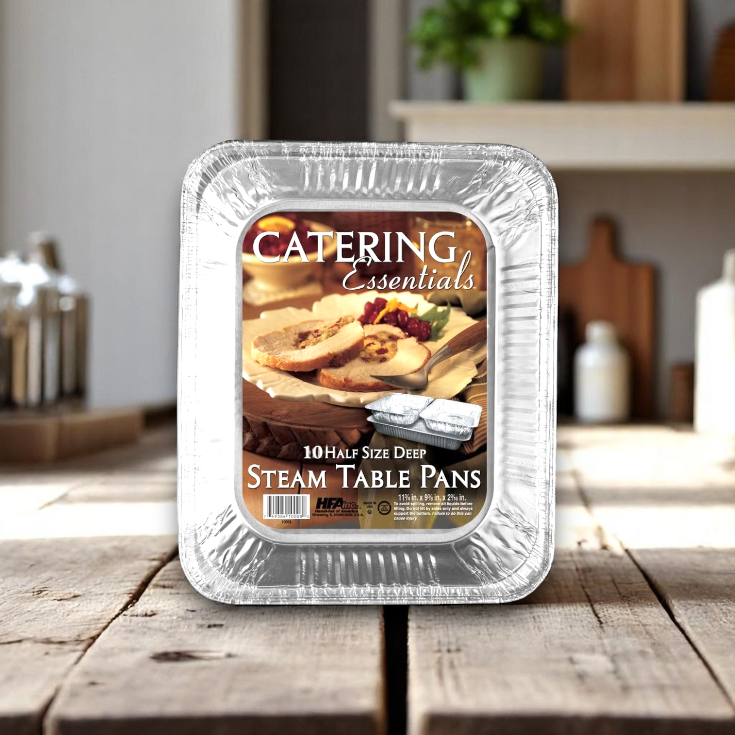 A Handi-Foil of America HFA Half-Size Deep Steam Table Pan from the 10-count pack (12 packs per case) is displayed on a wooden kitchen table.