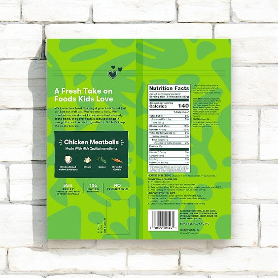 Against a white brick wall, the back of the Kidfresh Frozen Chicken Meatballs - 16.45 oz package is displayed, featuring nutritional facts, ingredients list, and product information. It emphasizes the high-quality ingredients and hidden veggies in Kidfresh Chicken Meatballs, ensuring a nutritious meal for all.
