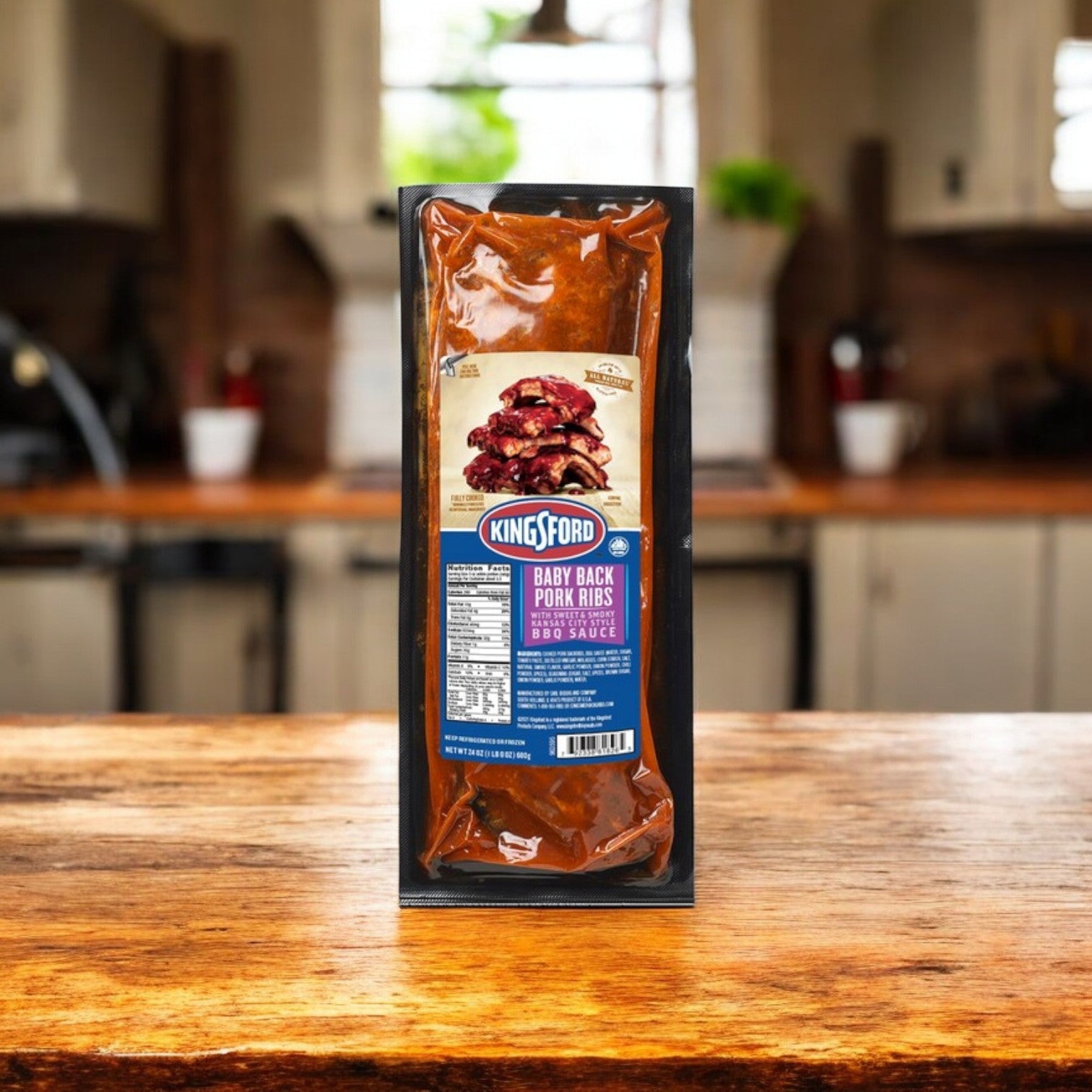 Kingsford Pork Ribs, Baby Back, with Sweet & Smoky Kansas City BBQ Sauce – 24 oz. -3 Packs stand proudly on a wooden kitchen counter, blurred kitchen background.