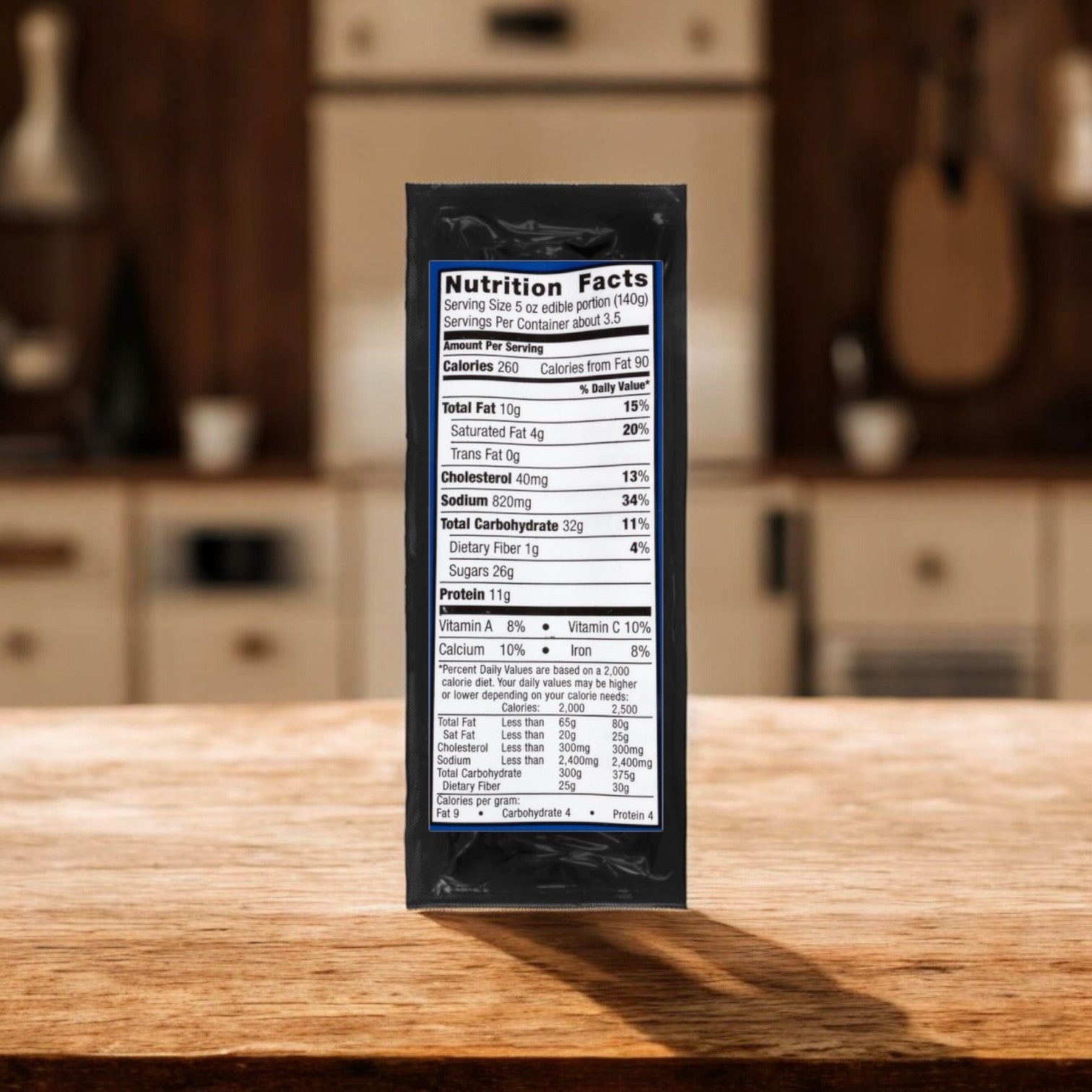 A nutrition facts label from a black Kingsford pork ribs package featuring Sweet & Smoky Kansas City BBQ Sauce rests on a wooden kitchen counter, with a blurred background of kitchen cabinets and grilling utensils.