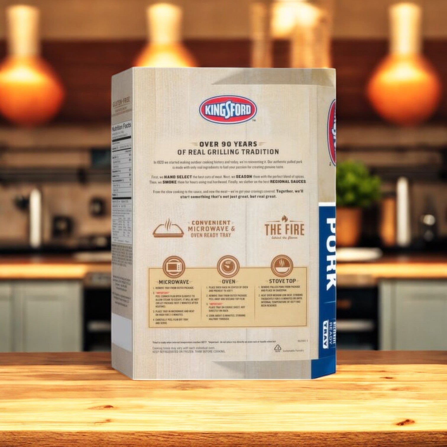 A box of Kingsford Pulled Pork with Sweet & Smoky Kansas City Style BBQ Sauce – 16 oz sits on a wooden kitchen counter. The aroma hints at barbecue goodness, creating an inviting and cozy kitchen setting.