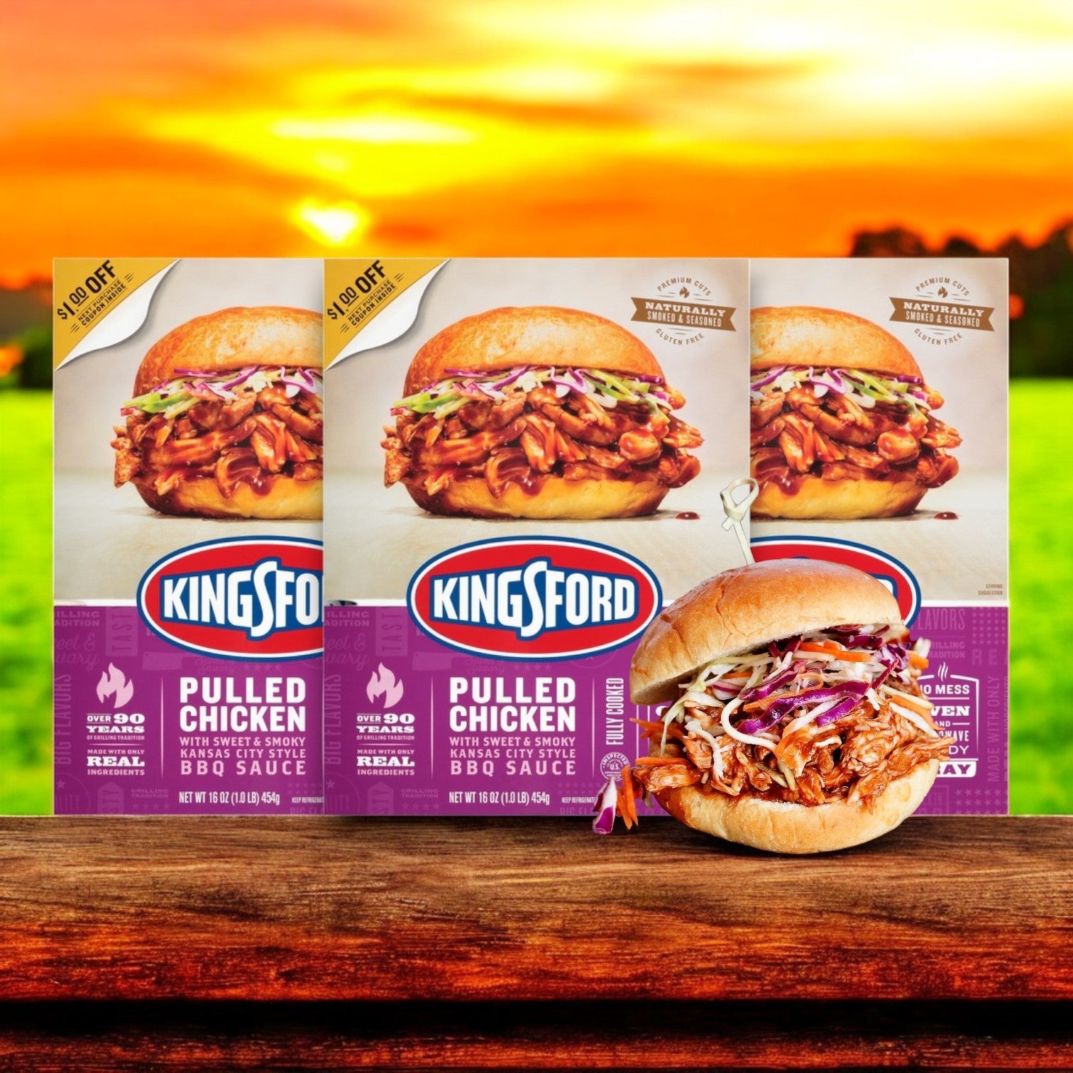 Three boxes of Kingsford Pulled Chicken – 16 oz -3 Count are shown against a sunset backdrop, with a sandwich loaded with slow-smoked barbecue chicken, creamy coleslaw, and a crunchy pickle.