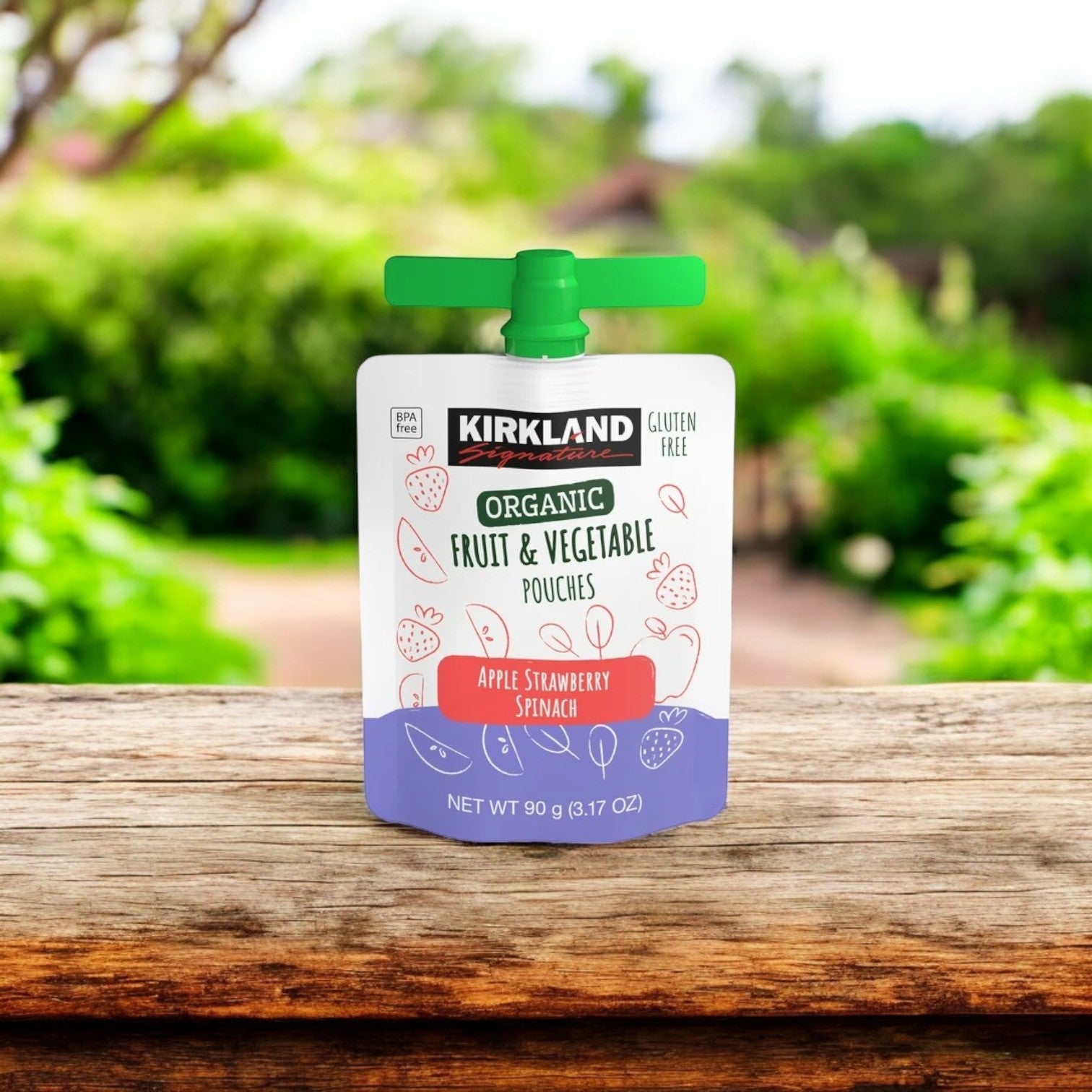 Kirkland Signature Organic Fruit and Vegetable Pouches Variety Pack rests on a wooden surface with a blurred garden backdrop—a perfect choice for a healthy lifestyle, especially the apple strawberry spinach flavor.