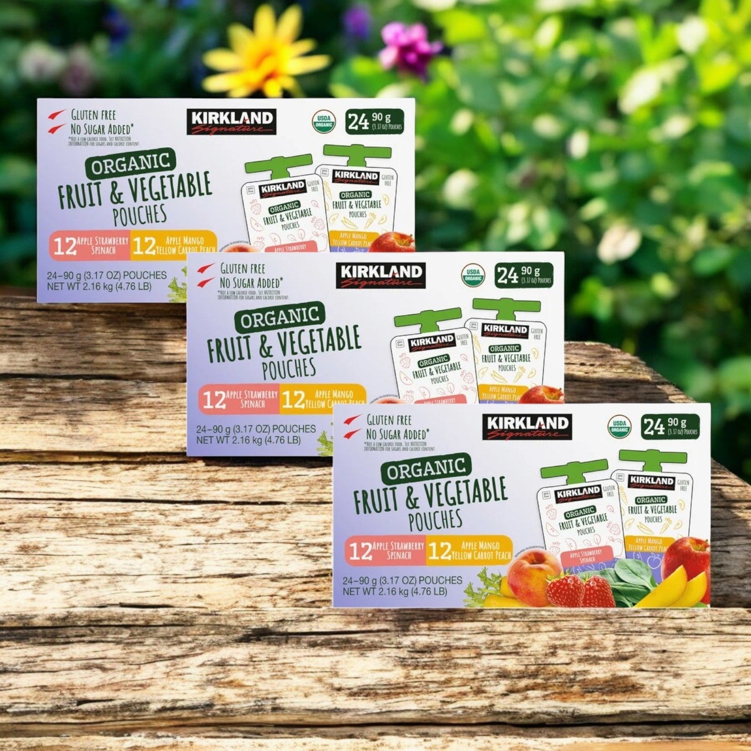 Three packs of Kirkland Signature Organic Fruit and Vegetable Pouches are displayed outdoors, each packed with 24 delightful fruit flavors such as apple, strawberry, and mango.