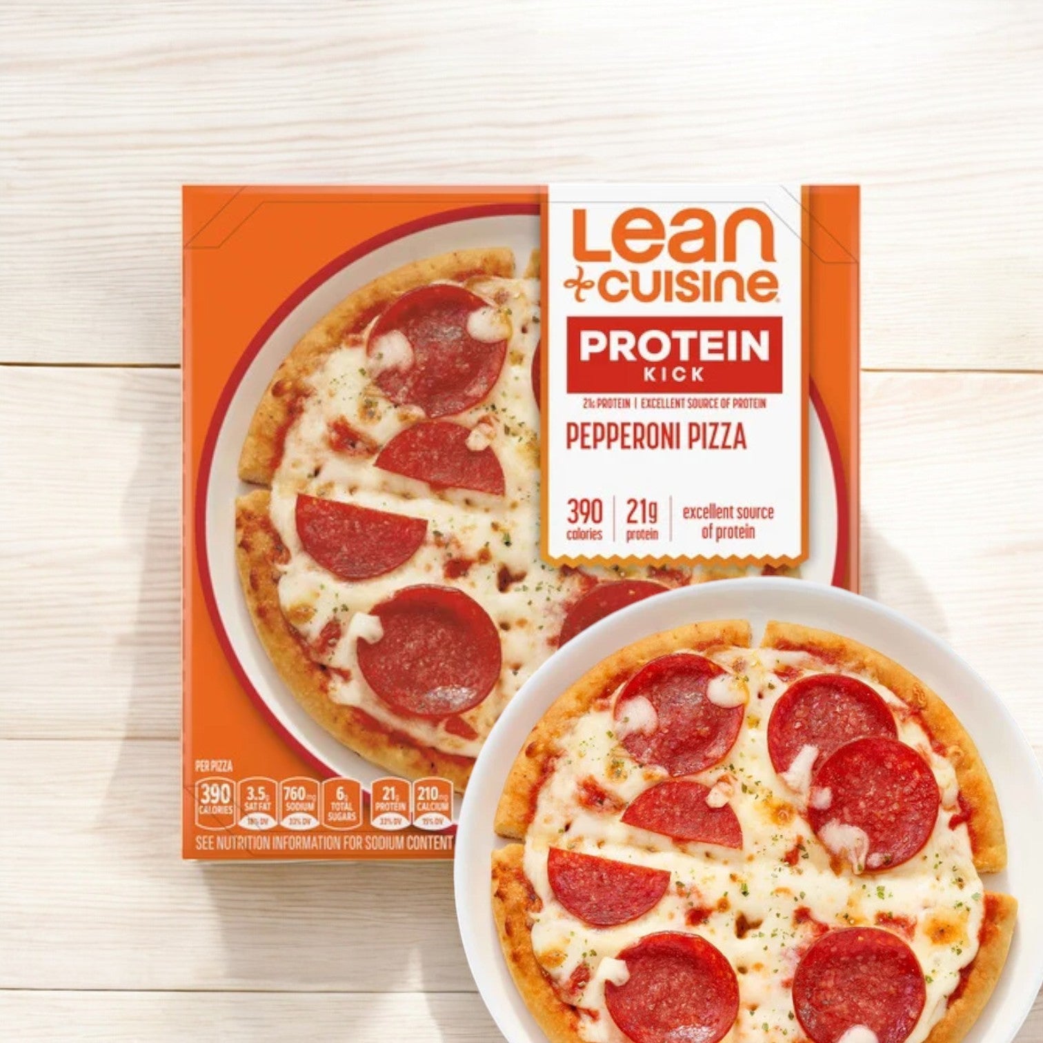 Box of Lean Cuisine Pepperoni, 6 oz. - 1 Count, beside a bowl containing the pizza on a wooden surface. The box highlights nutritional info: 390 calories and 21g protein. Perfect alongside a Lean Cuisine Chicken Teriyaki Bowl for a balanced microwaveable meal option.