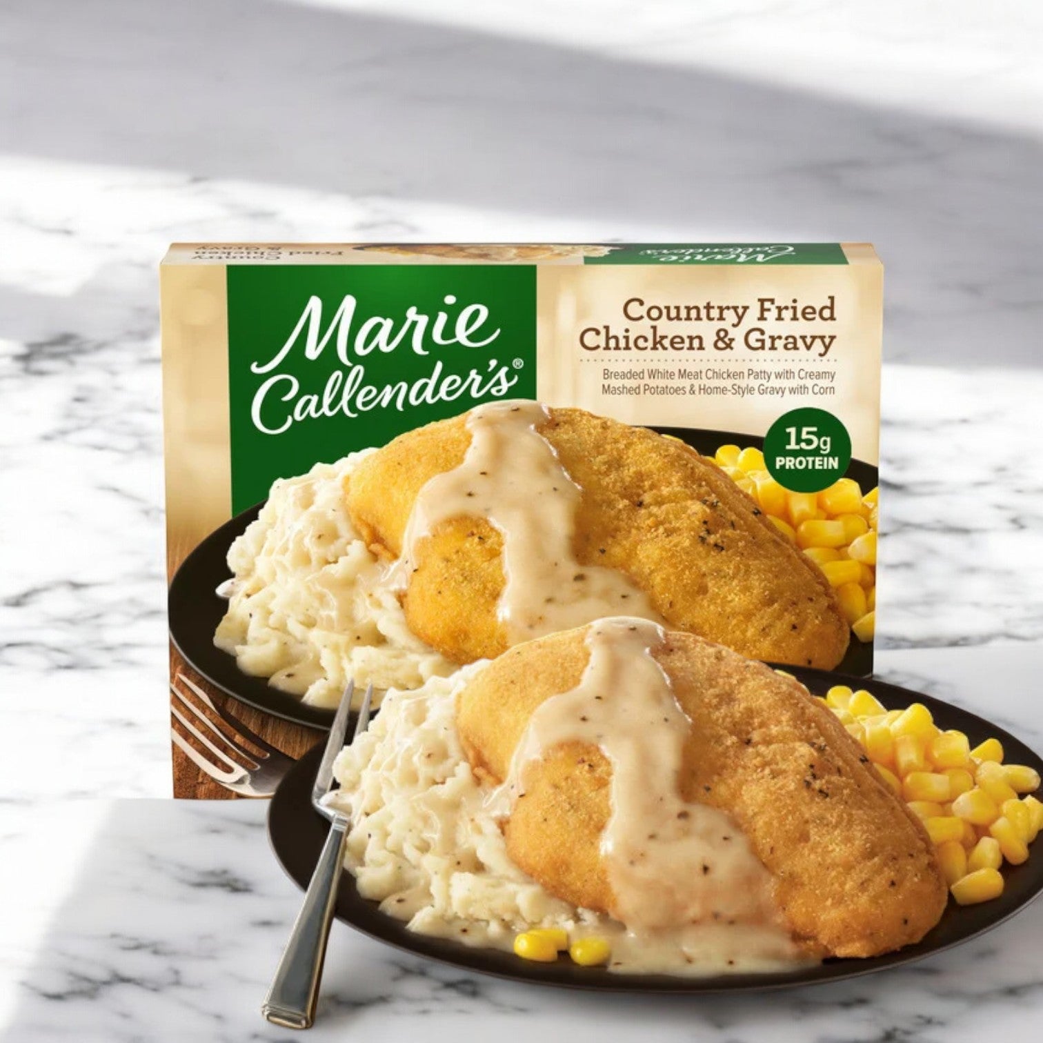 Marie Callender's Country Fried Chicken & Gravy, 13.1 oz. frozen meal includes a breaded chicken breast, mashed potatoes with gravy, and corn. The packaging shows the same meal served on a plate in the background. For a tasty Italian cuisine option, try Marie Callender's Spaghetti.