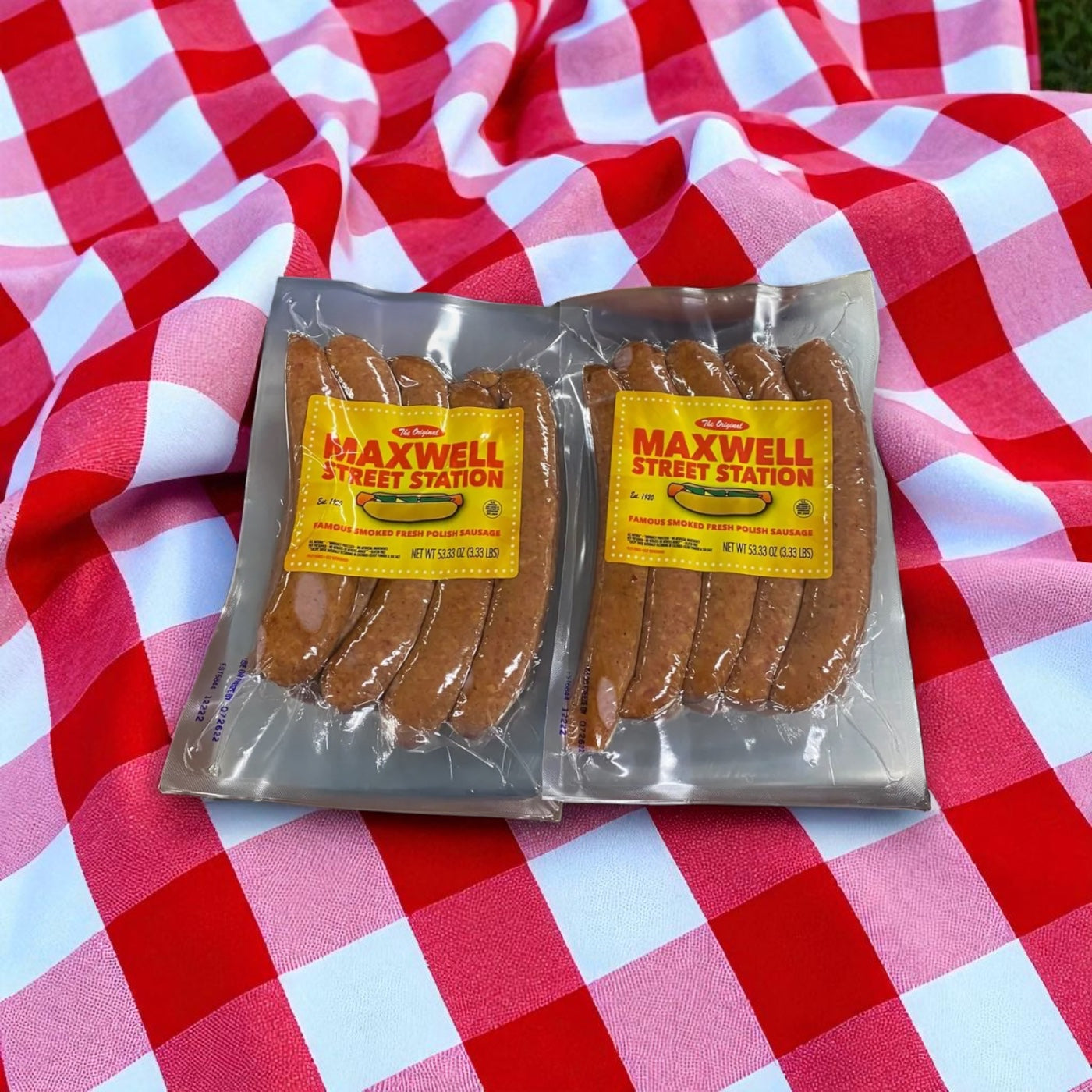 A pack of Vienna Beef Maxwell Street Station Famous Smoked Fresh Polish Sausage, 53.33 oz., sits on a red and white checkered picnic blanket.