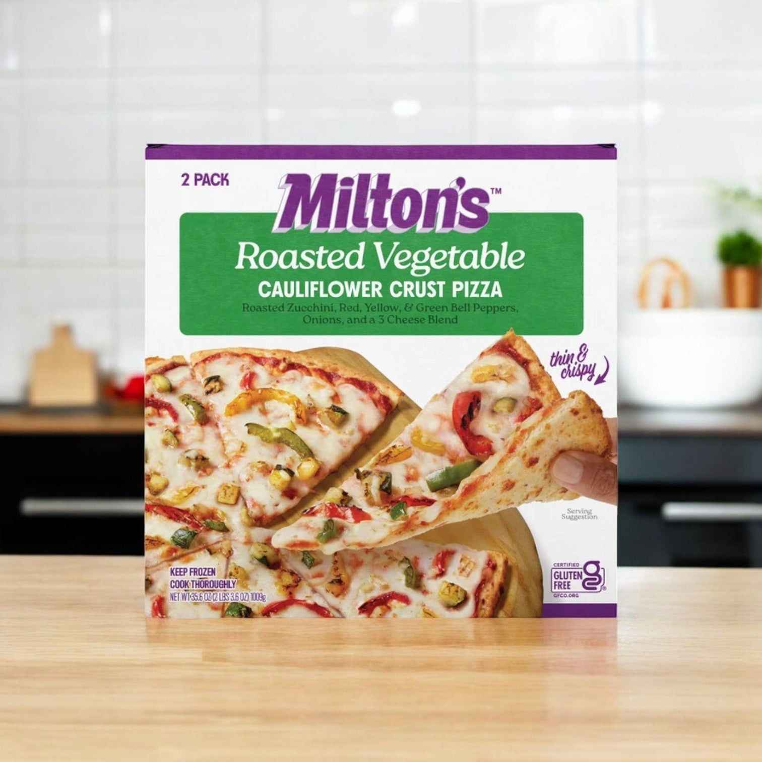 A box of Milton's Cauliflower Crust Pizza, Roasted Vegetable is on the counter, featuring an appetizing image of a veggie pizza topped with assorted vegetables and melted cheese.