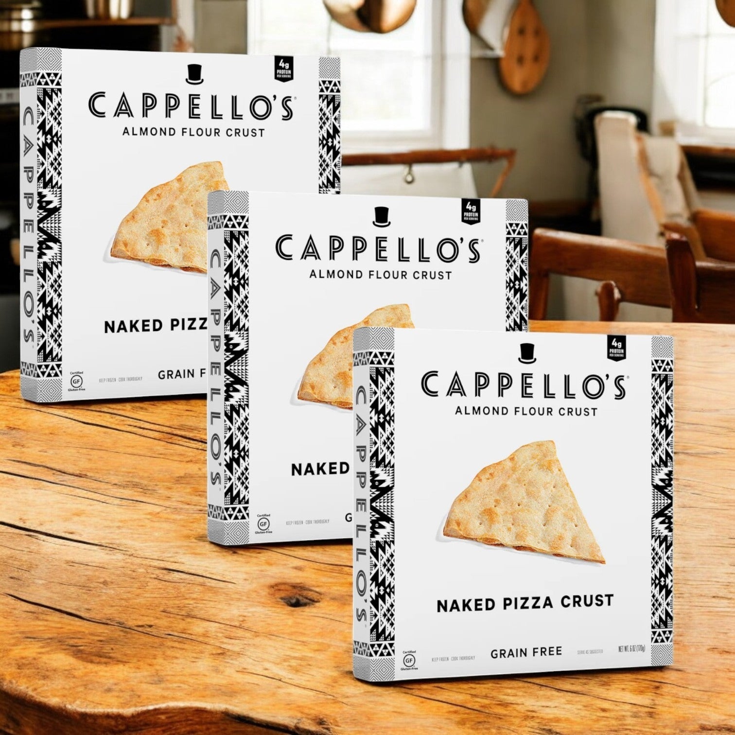 Three boxes of Cappello's Grain Free Naked Pizza Crust, 6 oz, are elegantly displayed on a wooden kitchen table, highlighting their gluten-free and grain-free excellence.
