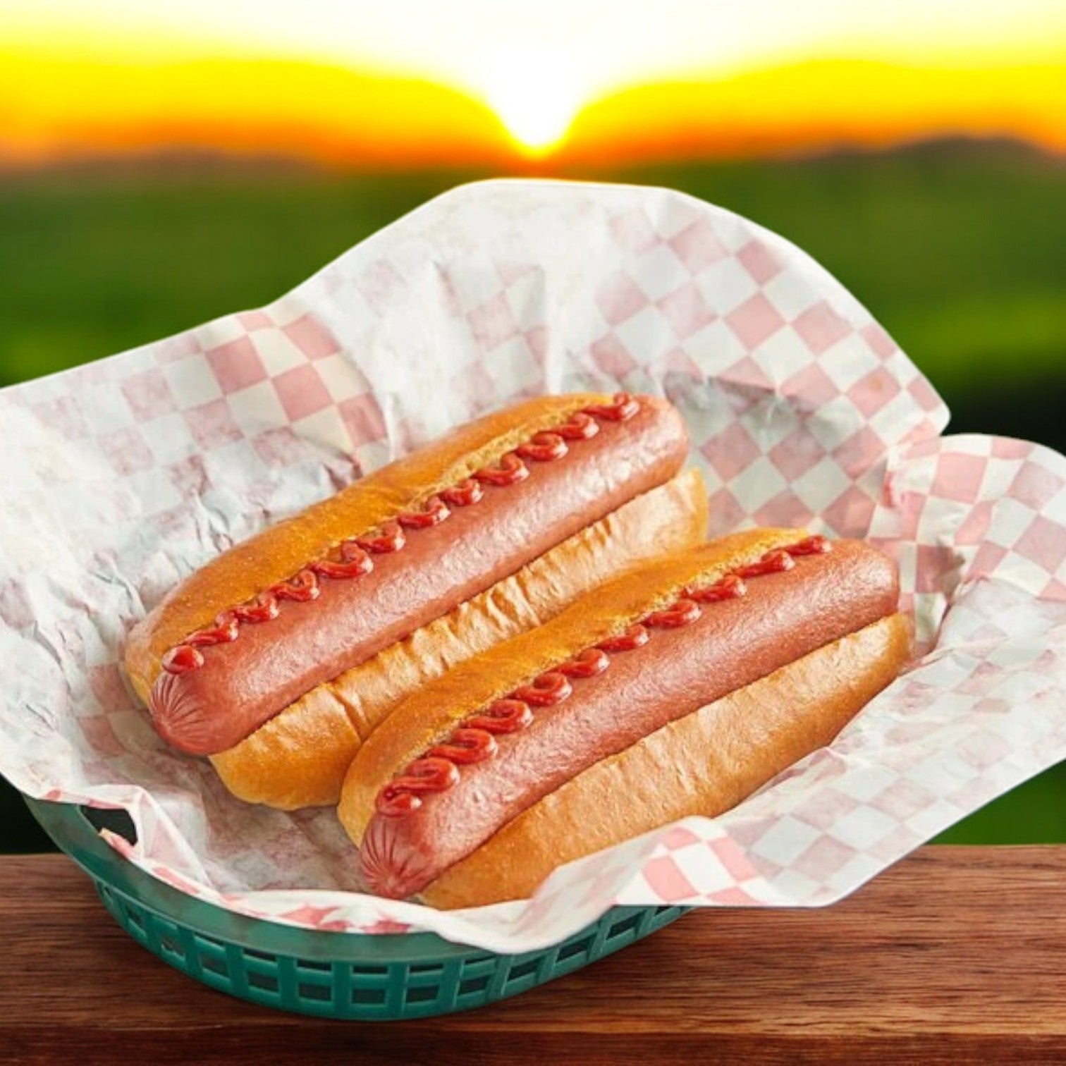 Two Nathan’s Famous Skinless Beef Franks with ketchup in buns, nestled in a green basket lined with checkered paper, bask in the glow of a sunset background.