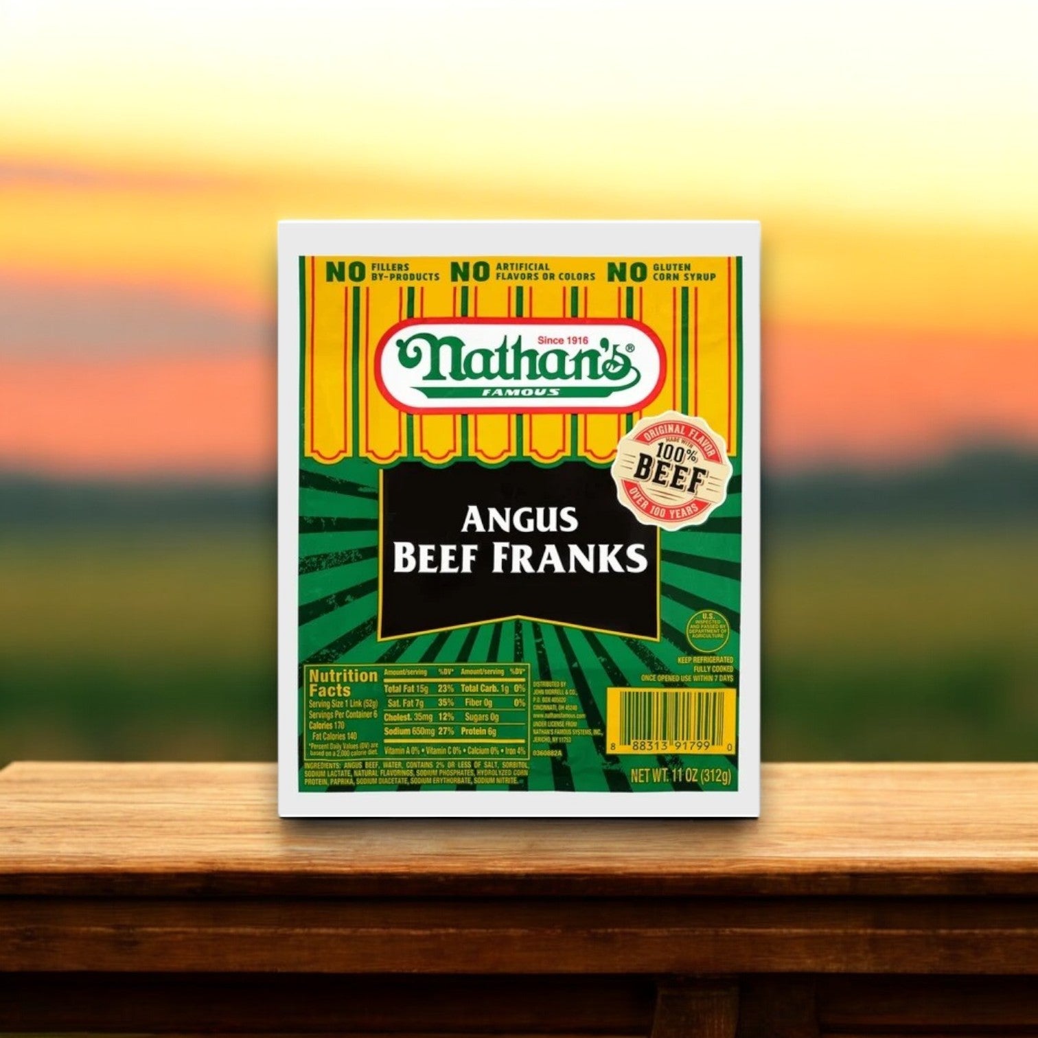 A package of Nathan's Bundle – 16 Count Angus Beef Hot Dogs & 16 Hot Dog Buns sits proudly against a blurred outdoor background, inviting you to enjoy an unbeatable taste experience.