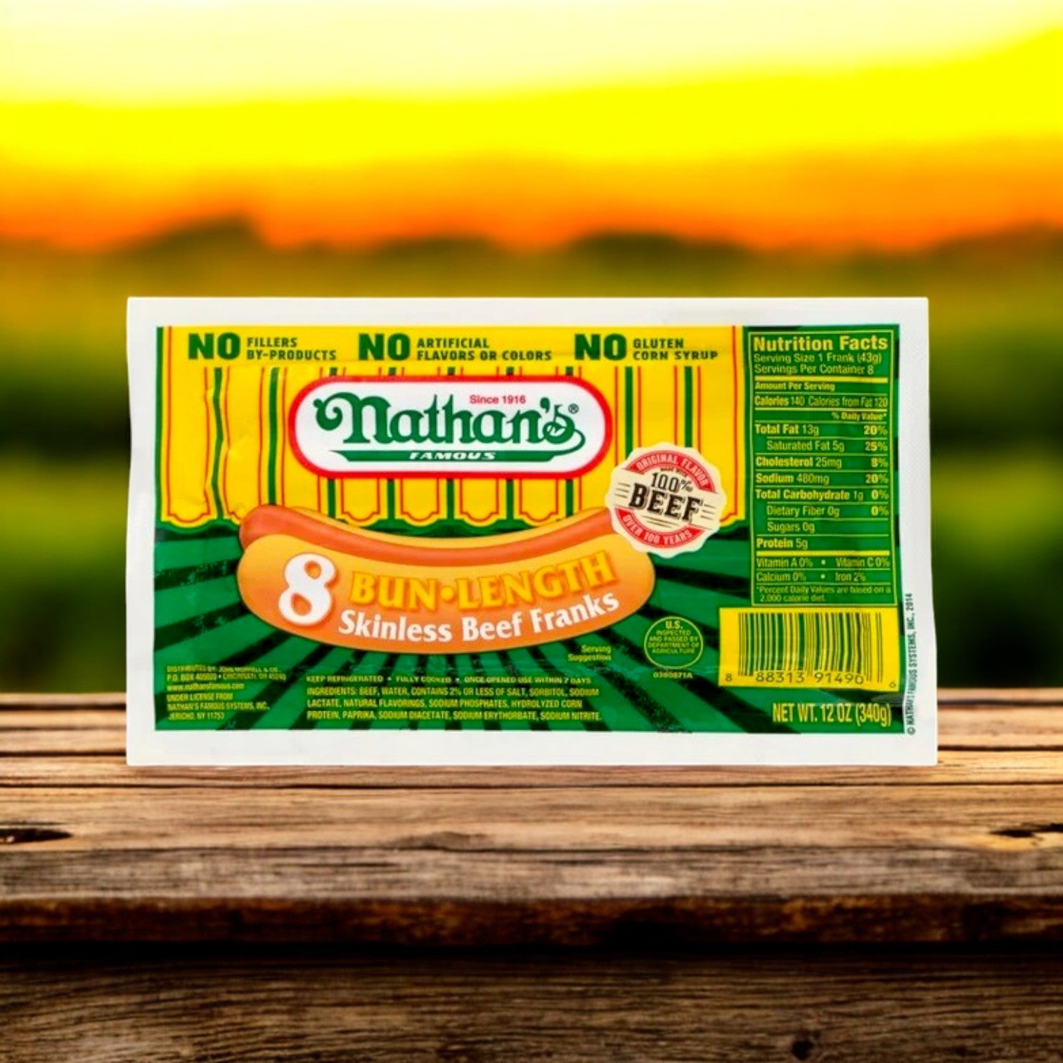 A package of Nathan's Famous Franks – 12 oz- 8 Franks is displayed on wood with a blurred outdoor backdrop. Made from 100% beef without by-products or artificial flavors, they capture the classic Nathan’s flavor.
