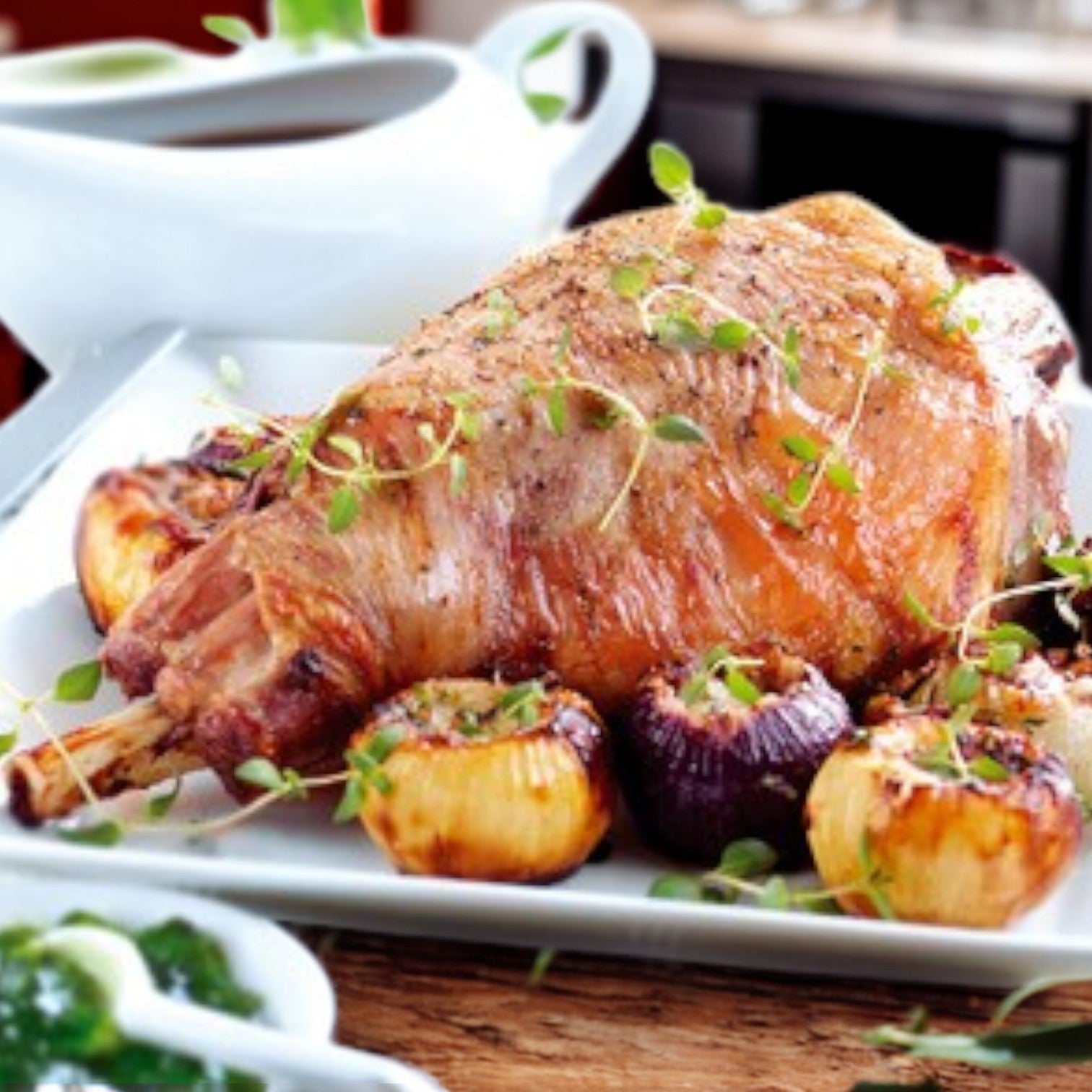 Enjoy a culinary delight with the New Zealand Spring Lamb Leg, Short Cut, featuring browned onions and herbs. Accompanied by a gravy boat and sides, this high-quality 5-pound lamb from New Zealand Spring Lamb ensures a memorable meal.