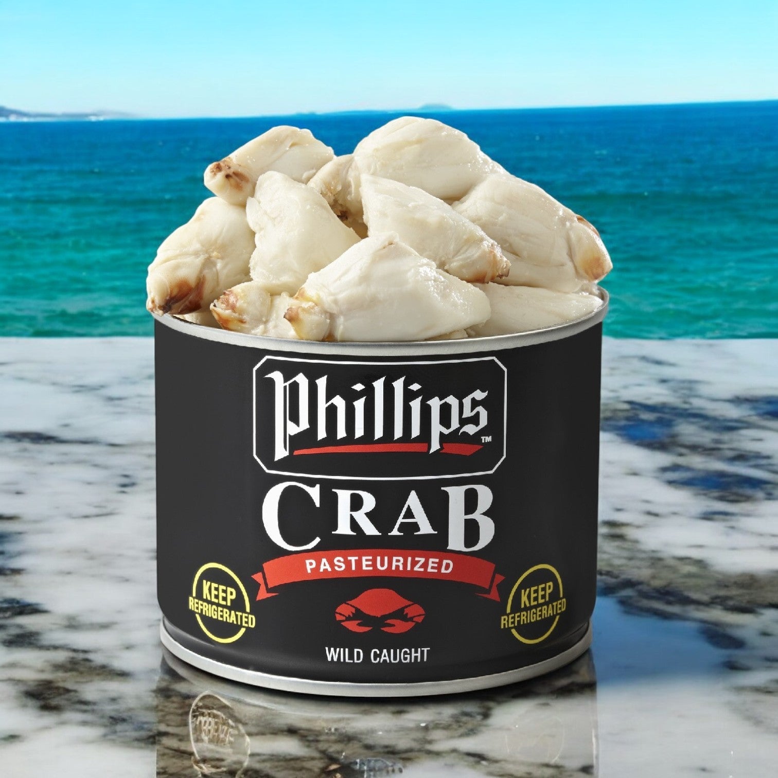 A 1-pound can of Phillips Foods' Culinary Jumbo Pasteurized Crab Meat sits on a marble surface, framed by a breathtaking ocean backdrop.