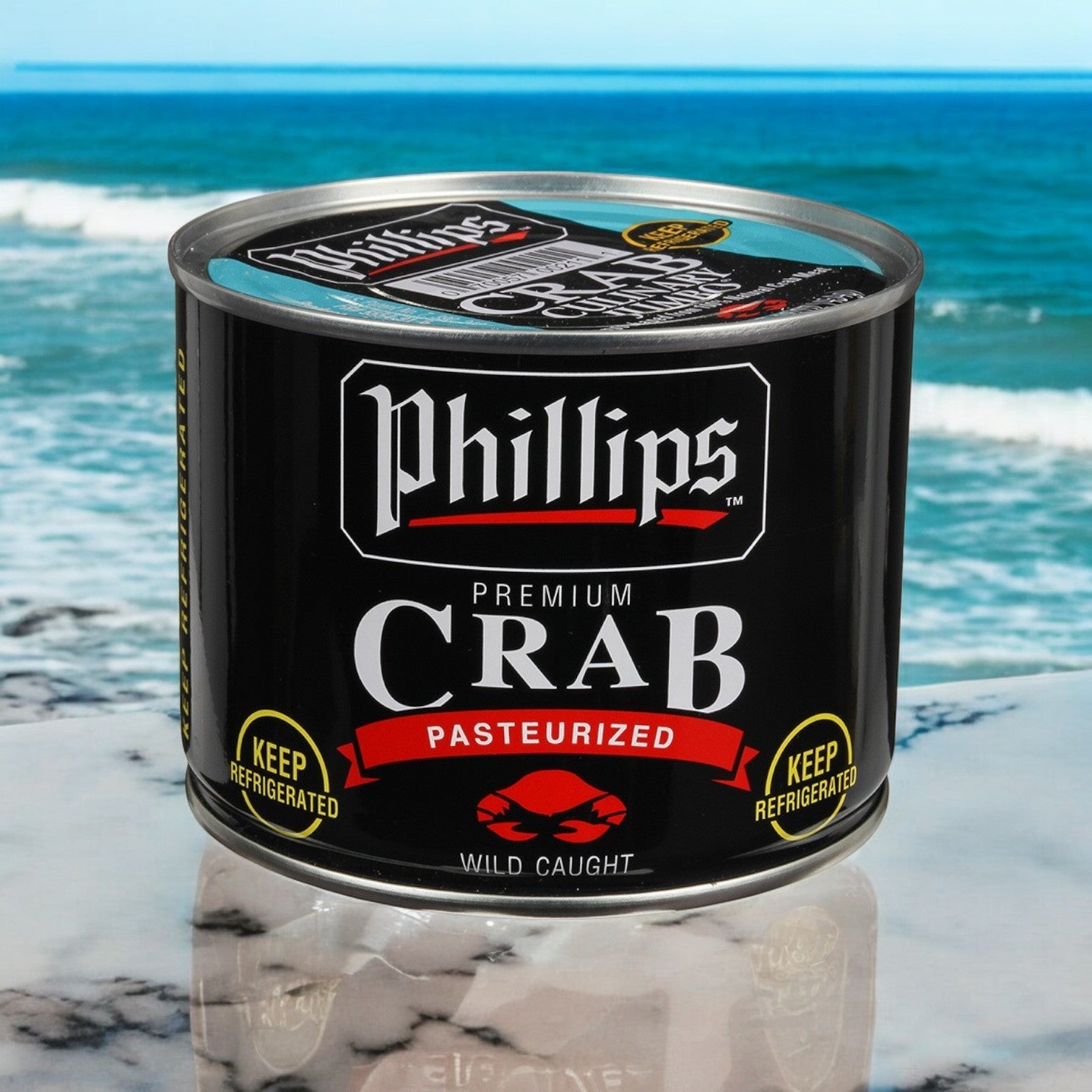 A can of Phillip Foods 1 Crab Meat Culinary Jumbo Pasteurized Asia Can, featuring wild-caught jumbo crab meat, sits elegantly on a marble surface with the ocean in the background.
