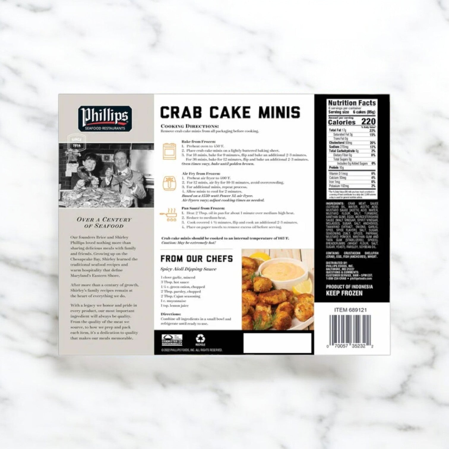 The packaging for Phillips Crab Cake Minis, from Phillips Foods, includes premium crab meat details and features cooking instructions, nutrition facts, and a serving suggestion of mini crab cakes with dipping sauce on a marble surface. Available as 1 lb 2 oz (3 count) or 108 count.