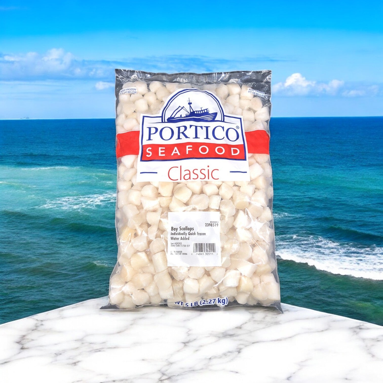 A 5lb bag of Portico Classic Seafood's IQF Scallops (80-120 count), displayed on marble with an ocean backdrop, highlights their premium quality.