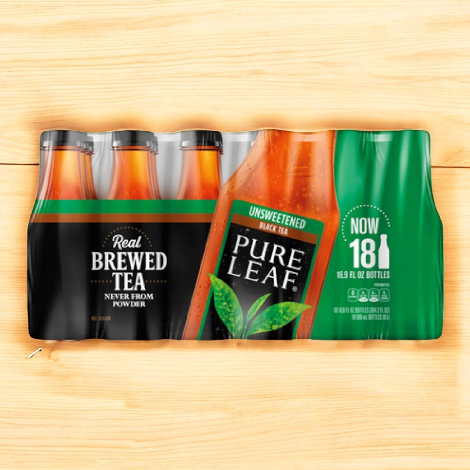 A case of Pure Leaf Brewed Tea sits on a wooden surface, displaying "Real Brewed Tea" and "18.9 fl oz bottles." Enjoy the refreshing unsweetened black tea taste with this convenient pack of 18 from Pure Leaf.