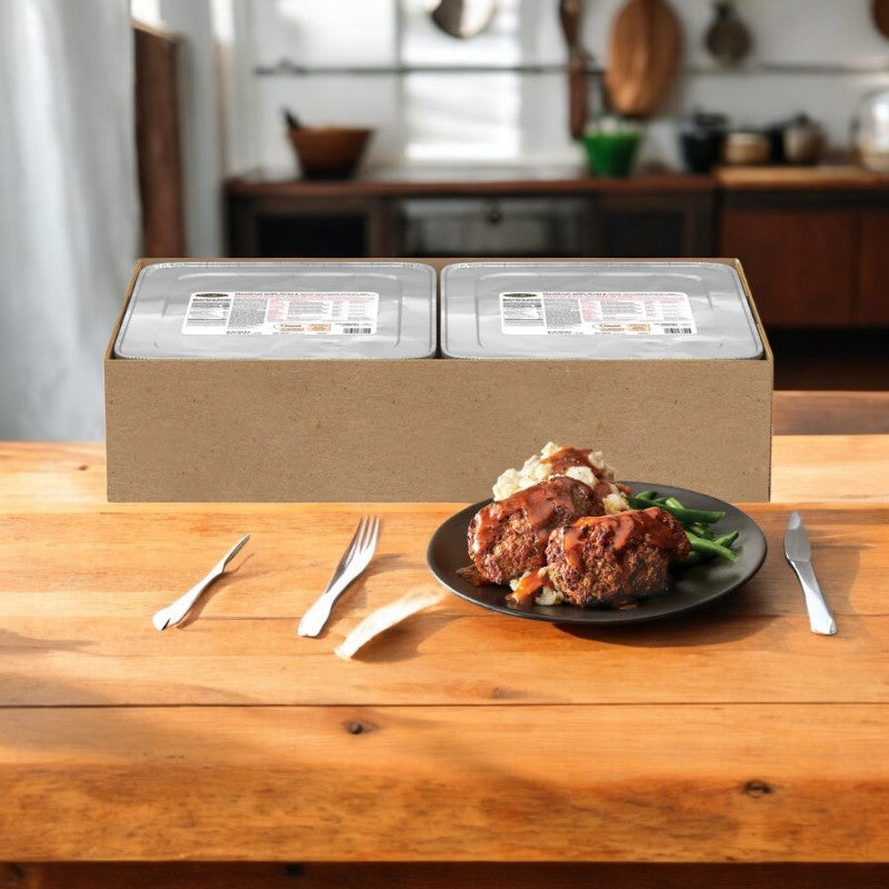 A kitchen counter displays packaged meal trays with a plate of Stouffer's Entree Meatloaf With Gravy, mashed potatoes, and green beans in the foreground.