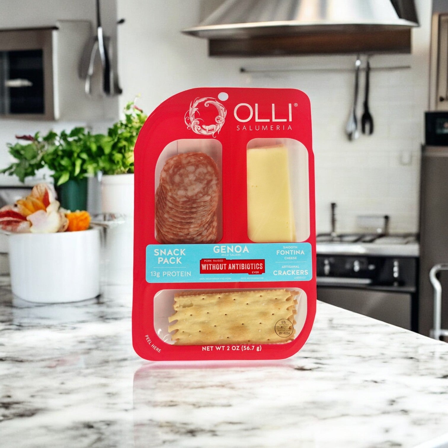 Olli's Salami Genoa Fontina Snack Pack, featuring creamy fontina cheese, Genoa salami, and crisp crackers, sits on a kitchen counter.