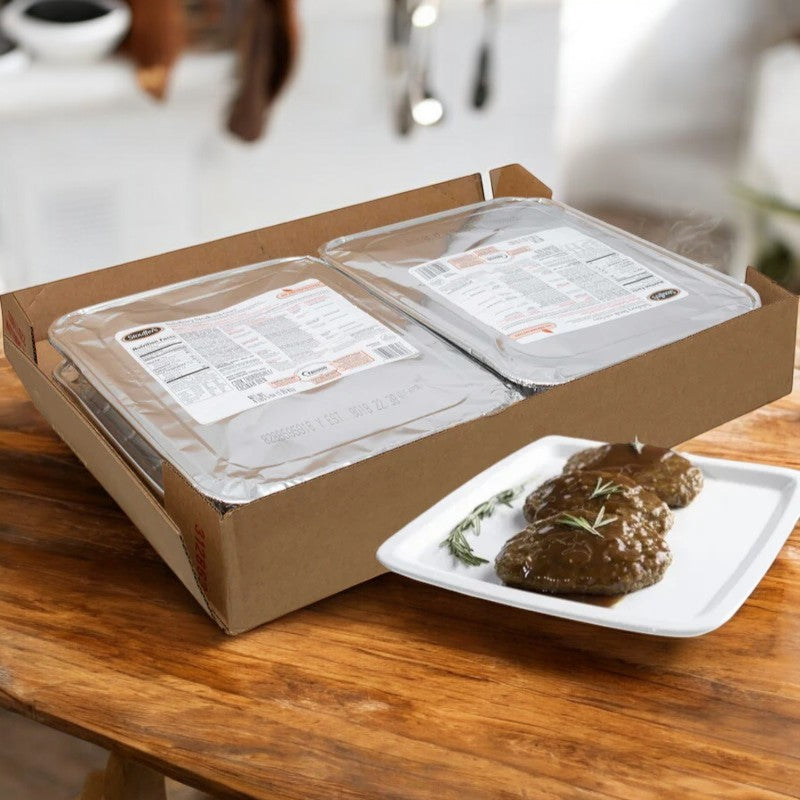 A cardboard box rests on a wooden table, brimming with Stouffer's Salisbury Steak with Gravy packages. A white plate in front displays the beautifully garnished steak smothered in rich gravy, creating the perfect kitchen scene for this hearty family meal.