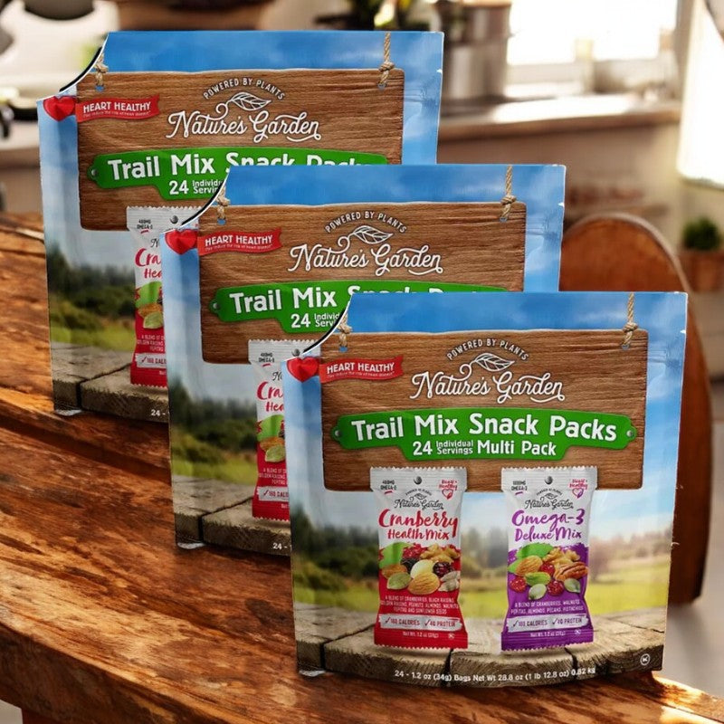 On a wooden table, three Nature Garden Trail Mix Snack Packs sit—each featuring 24 portions of either Cranberry Health Mix or Omega-3 Deluxe Mix.