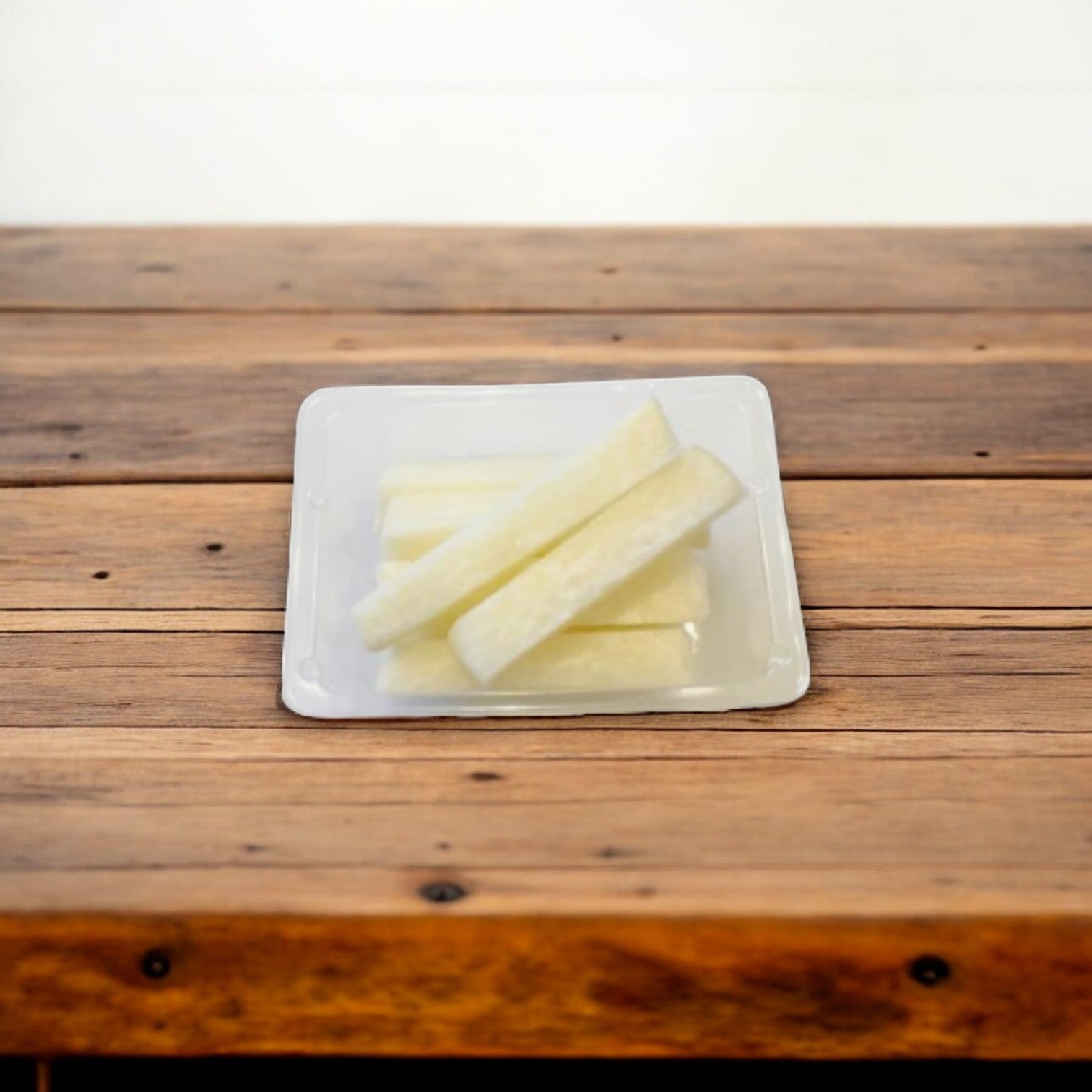 An Easy Lunches plastic tray featuring slices of white cheese and nutritious Jicama Sticks, 2.5 oz from a 50 pack, is set on a wooden table.