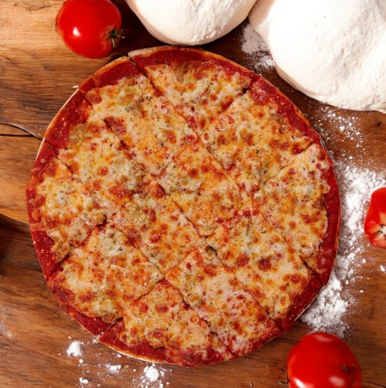 A Labriola Chicago Sausage Thin Crust Pizza, featuring mozzarella on a 12-inch base, sits sliced on wood amidst cherry tomatoes and floury dough balls.