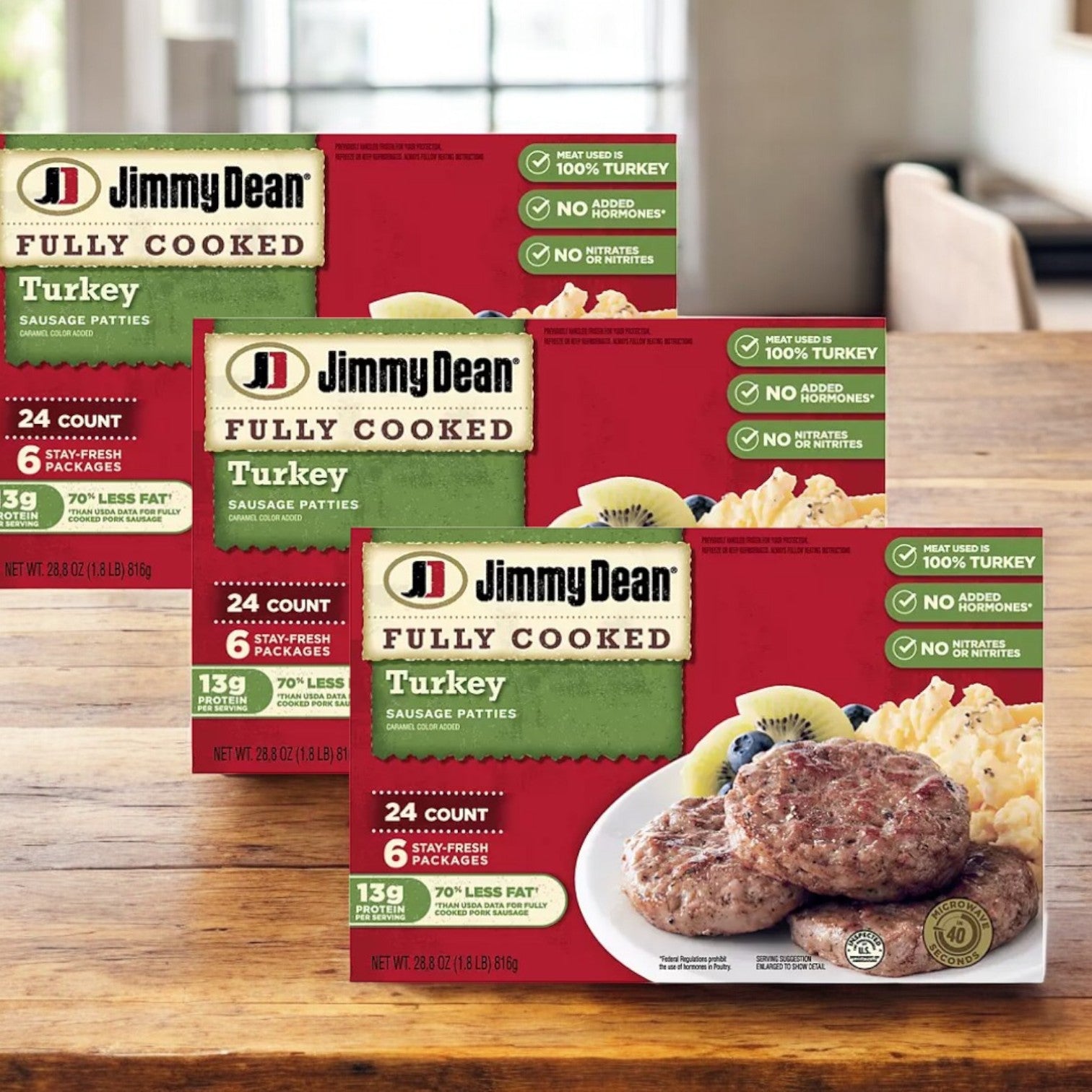 Three cases of Jimmy Dean Fully Cooked Turkey Sausage Patties, each with 24 patties made from 100% turkey, are arranged on a wooden table. These patties are a lean breakfast sausage option that emphasizes nutritional benefits.