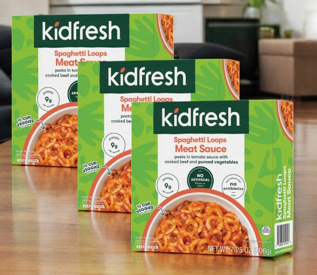 Three packages of Kidfresh Frozen Spaghetti Loops With Meat Sauce, 7.25 oz., rest on a wooden surface, their packaging showcasing hidden vegetables and nutrition details while emphasizing organic pasta with no artificial ingredients.