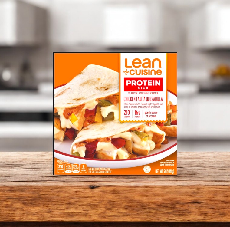 A package of Lean Cuisine Chicken Fajita Quesadilla (5 oz, 1 count) sits on a wooden surface, highlighting a tasty frozen meal featuring chicken and vegetables wrapped in a quesadilla.