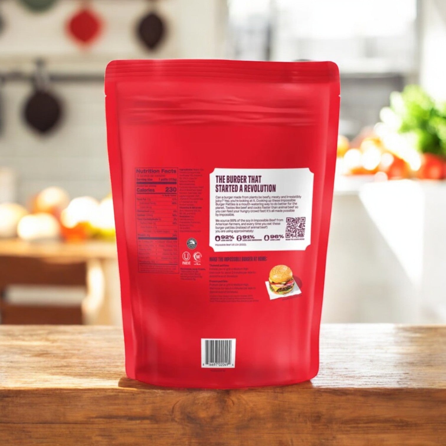 A red package of Impossible Foods' Impossible Burger Patties Made From Plants (10 count, 3 packs) sits on a wooden kitchen counter, emphasizing its soy protein content, with blurred kitchen items in the background.