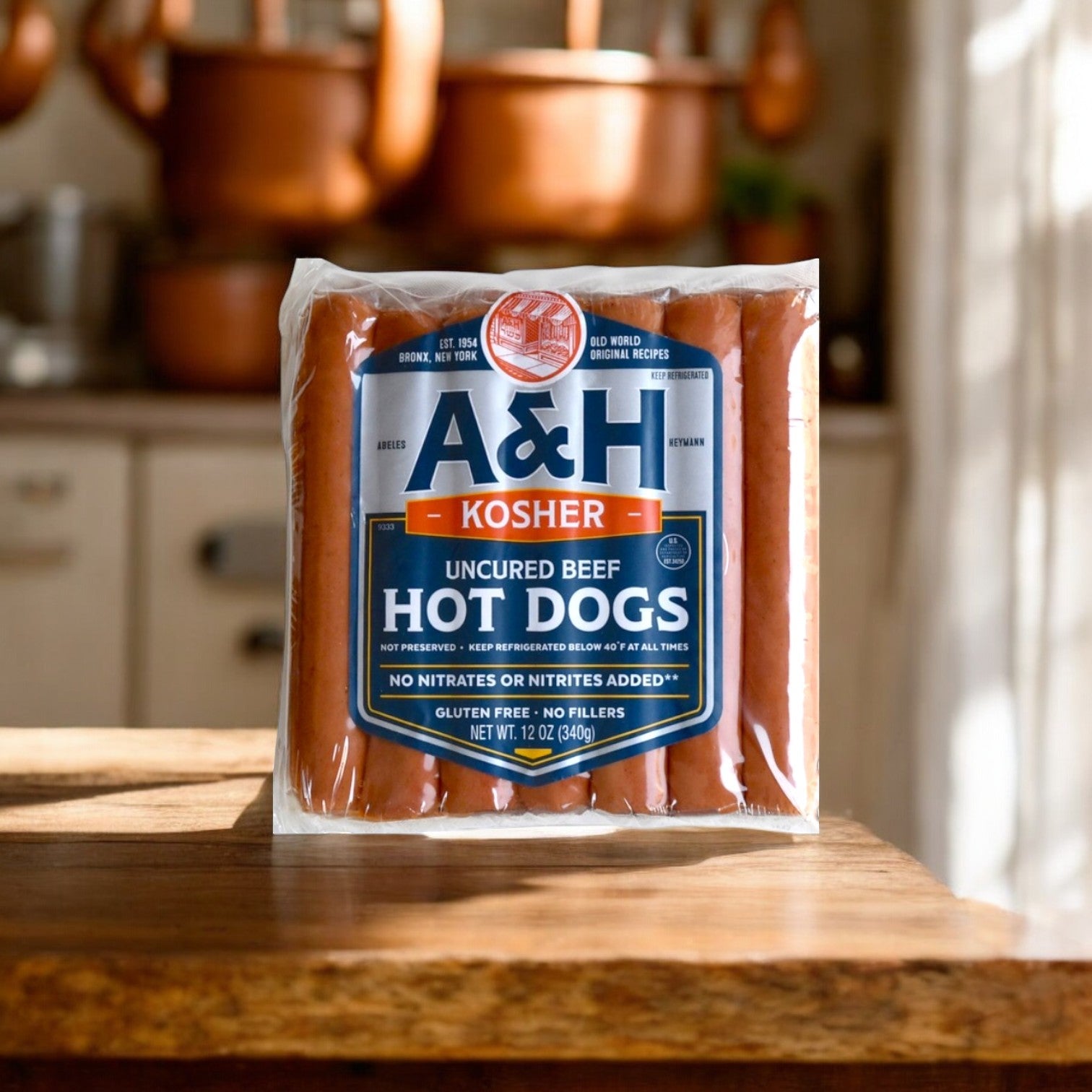 A pack of A&H Meats' A & H All Beef Kosher Hot Dogs, 12oz-1 Pack, sits on a wooden countertop in a cozy kitchen.