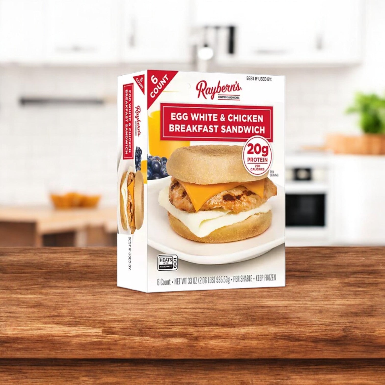 A Raybern's Egg White and Chicken Breakfast Sandwich- 1 Pack sits on the counter, offering 20g of protein per sandwich. Each package has six savory sandwiches made with egg whites for a wholesome breakfast.