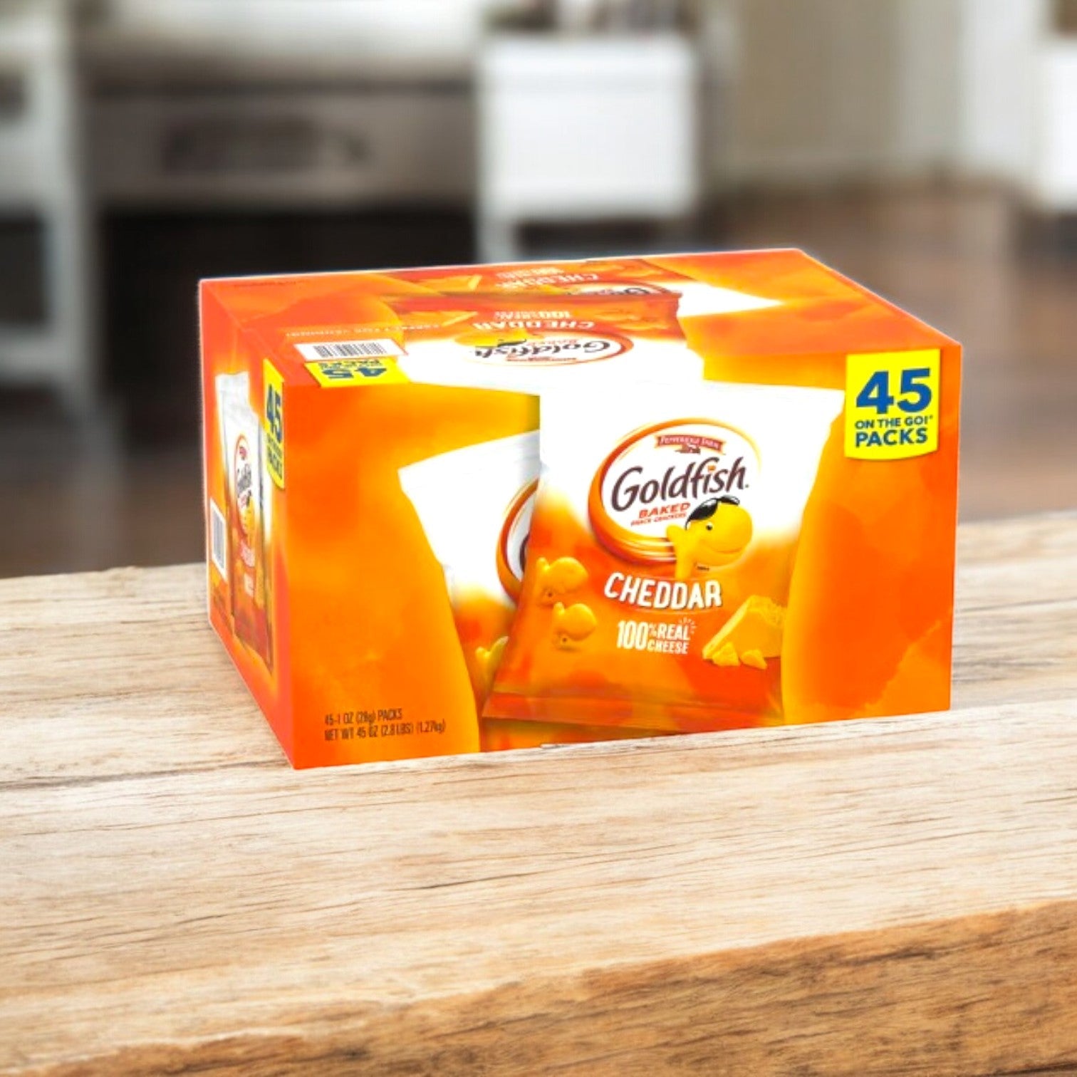 A box of Pepperidge Farm's Goldfish Baked Snack Crackers, Cheddar, 45-count pack, rests invitingly on a wooden surface in a cozy kitchen setting.