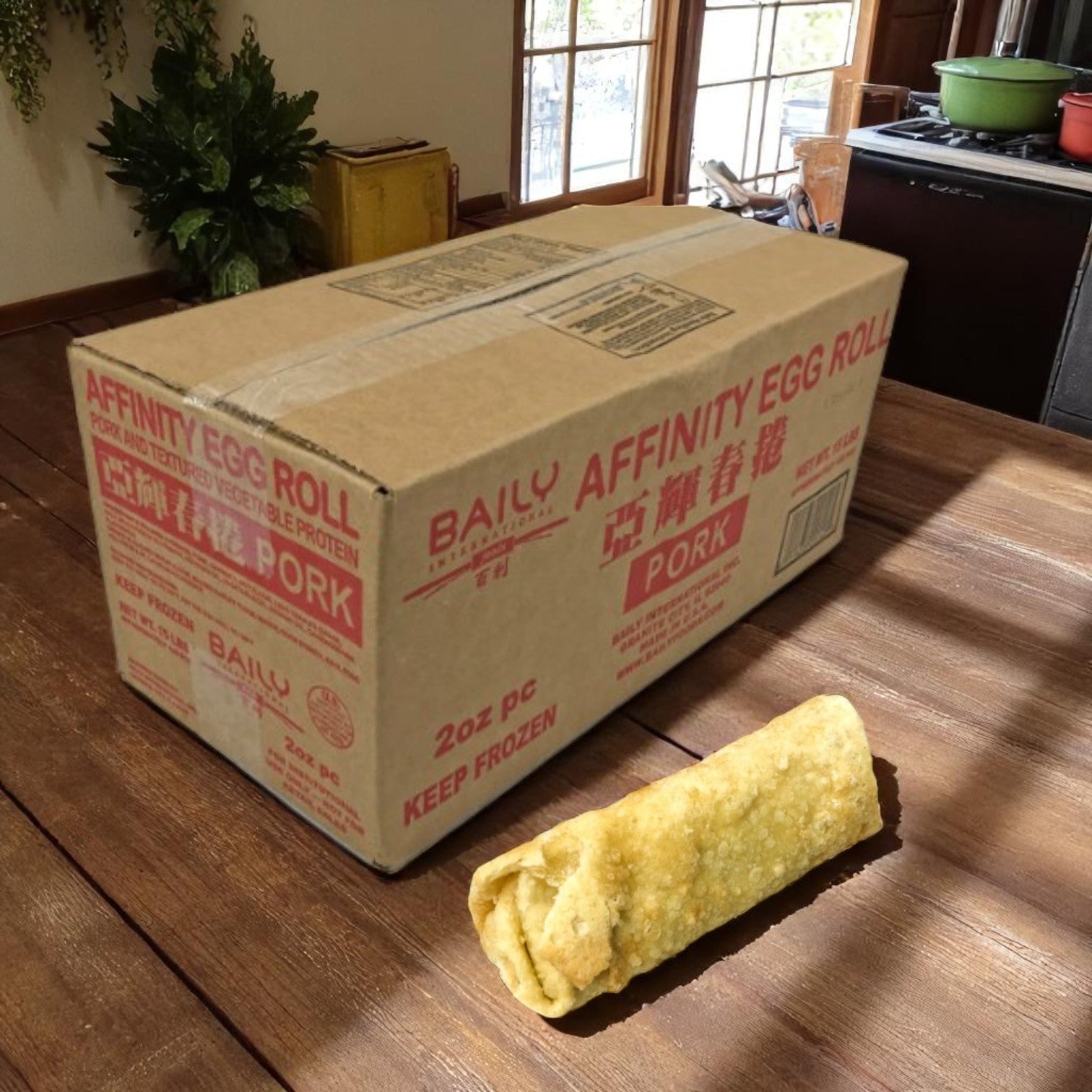 A Sysco-branded box labeled “Eggroll Pork Affinity-2 Oz-120 Count-1 Case” sits on a wooden table, displaying frozen Asian-style appetizers with one eggroll in front—ideal for foodservice operations.