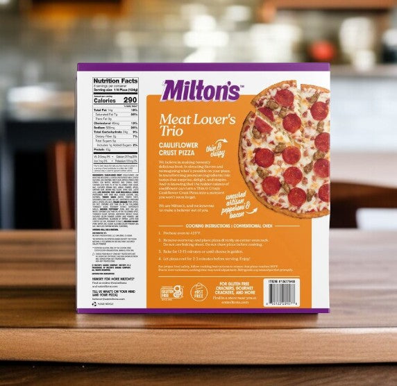 Milton’s Meat Lover’s Cauliflower Crust Pizza, 17.5 oz, 2-count box from Milton’s is displayed on a kitchen table with nutrition facts visible—ideal for those seeking a gluten-free frozen pizza option.