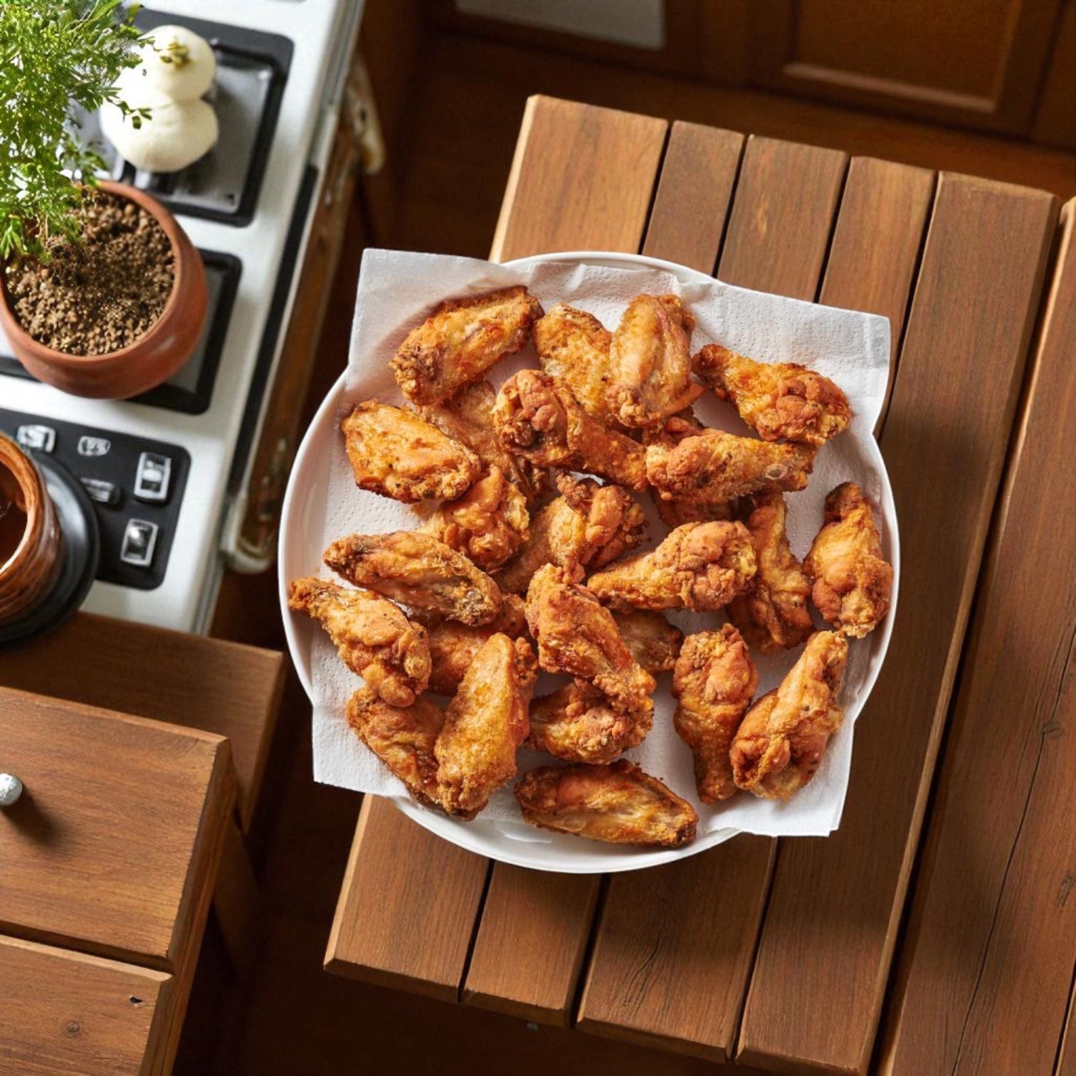 A plate of Tyson Foods Chicken Wing Stinger Pre-cooked 1st & 2nd Joints from a 5 lb bag is displayed on a wooden table, featuring crispy, golden-brown bone-in wings perfect for sharing.