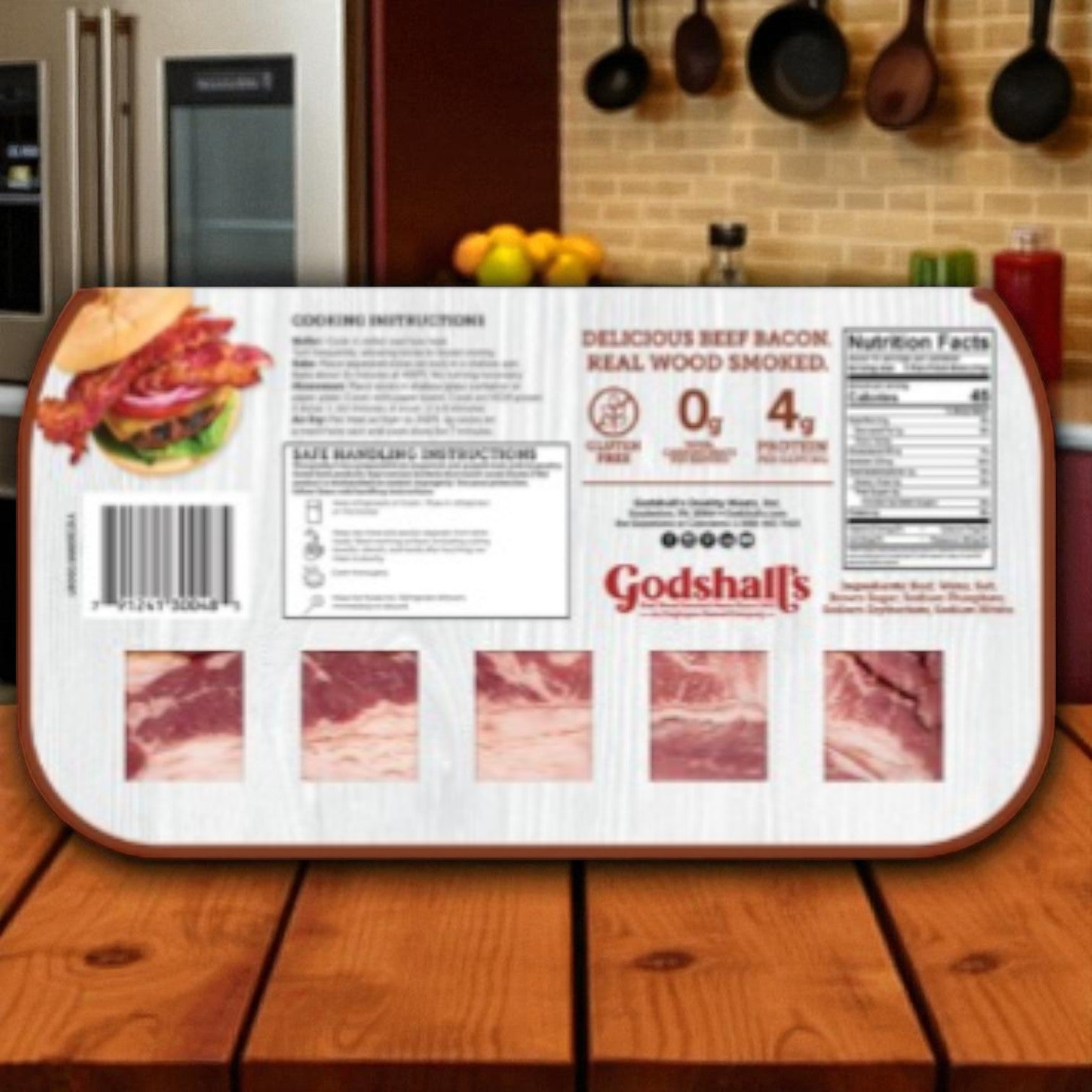 A package of Godshall's Beef Bacon-10 Oz-1 Pack by Godshall's sits on a wooden counter, showing nutrition facts, gluten-free and keto-friendly labels, cooking instructions, barcode, and visible bacon slices through clear windows. Kitchen items in the background.