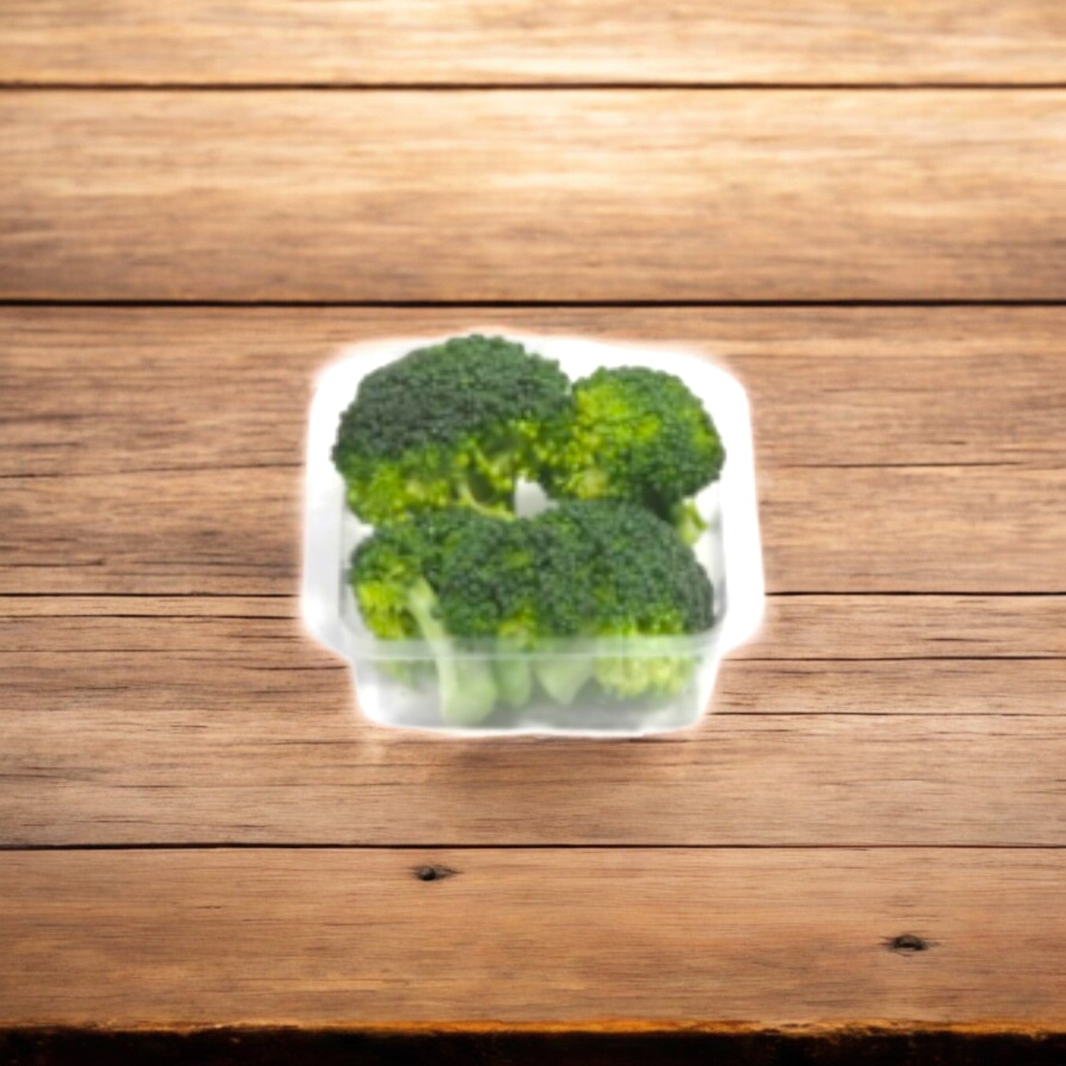 A nutrient-rich plastic container of Easy Lunches Broccoli Buds, 2.5 oz. from a 50-pack, rests on a wooden surface, offering abundant health benefits and a 7-day shelf life upon arrival.