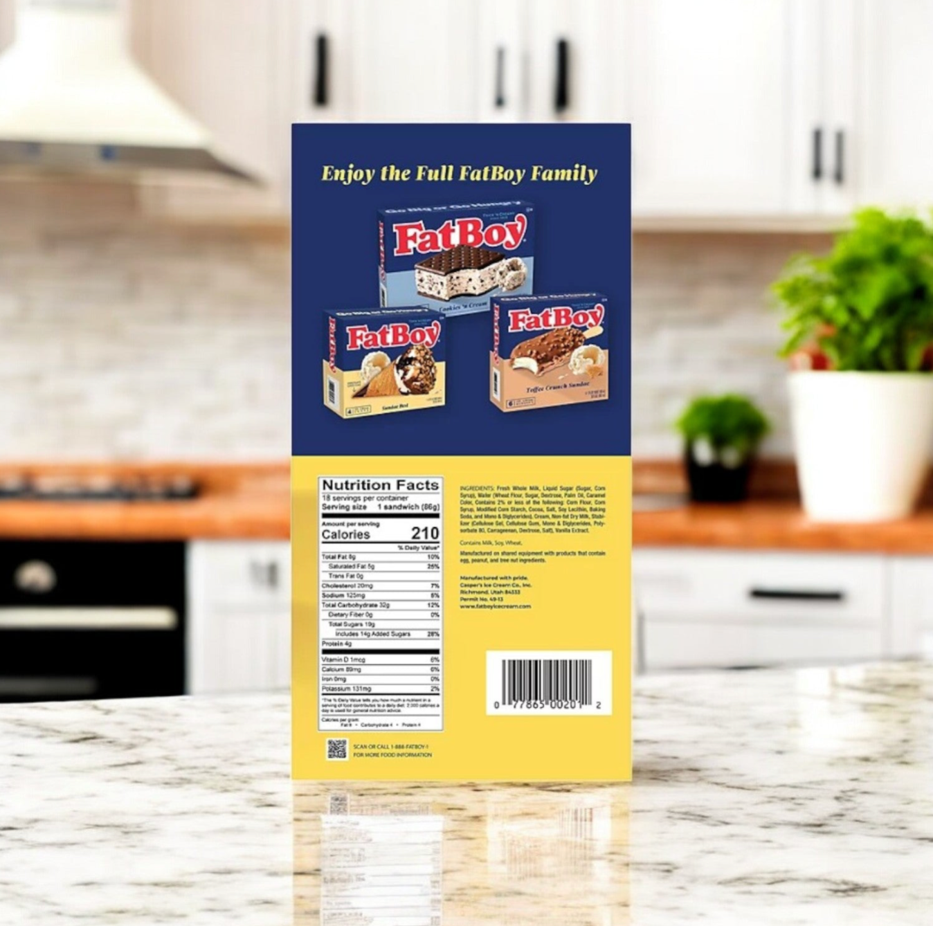 The back of a FatBoy Smores Sandwich Bars & Premium Vanilla Ice Cream Sandwich Combo box displays product images, nutrition facts, and features a kitchen countertop in the background.