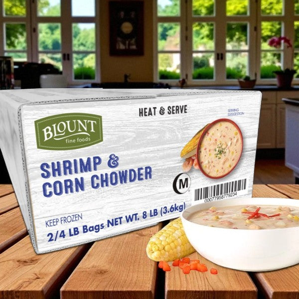 Blount Fine Foods Frozen Shrimp & Corn Chowder – 2 Packs, 4 lbs Each – creamy, coastal-style chowder, ready to heat and serve, displayed on a kitchen counter with a bowl of chowder and corn cob in front of kitchen windows.
