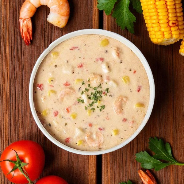 Blount Fine Foods' Frozen Shrimp & Corn Chowder (2 packs, 4 lbs each) is a creamy, coastal-style soup ready to heat and serve, shown garnished with herbs and surrounded by fresh tomatoes, parsley, shrimp, and corn.