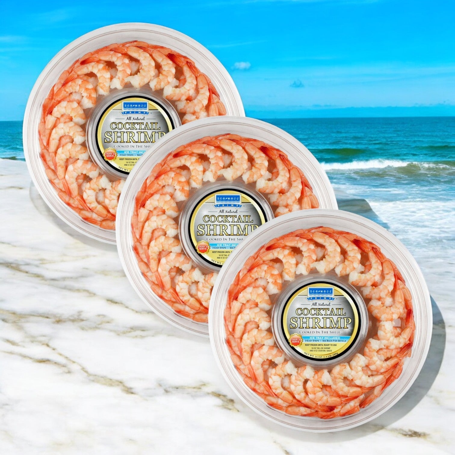 Three packs of Sea Mazz's Shrimp Platter, consisting of Seamazz Fully Cooked Cocktail Shrimp Rings (16 oz. each), are elegantly displayed on a marble surface with a stunning beach and ocean view in the background.